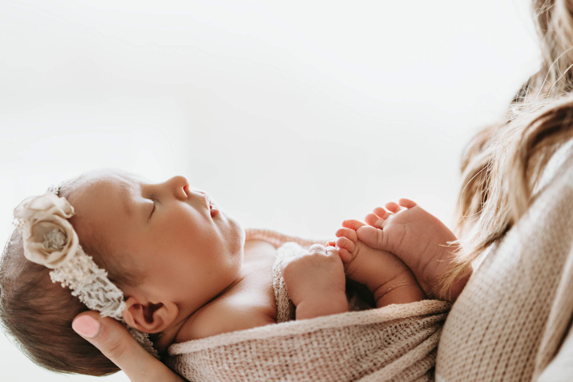 Sleeping newborn girl in her mother's arms
