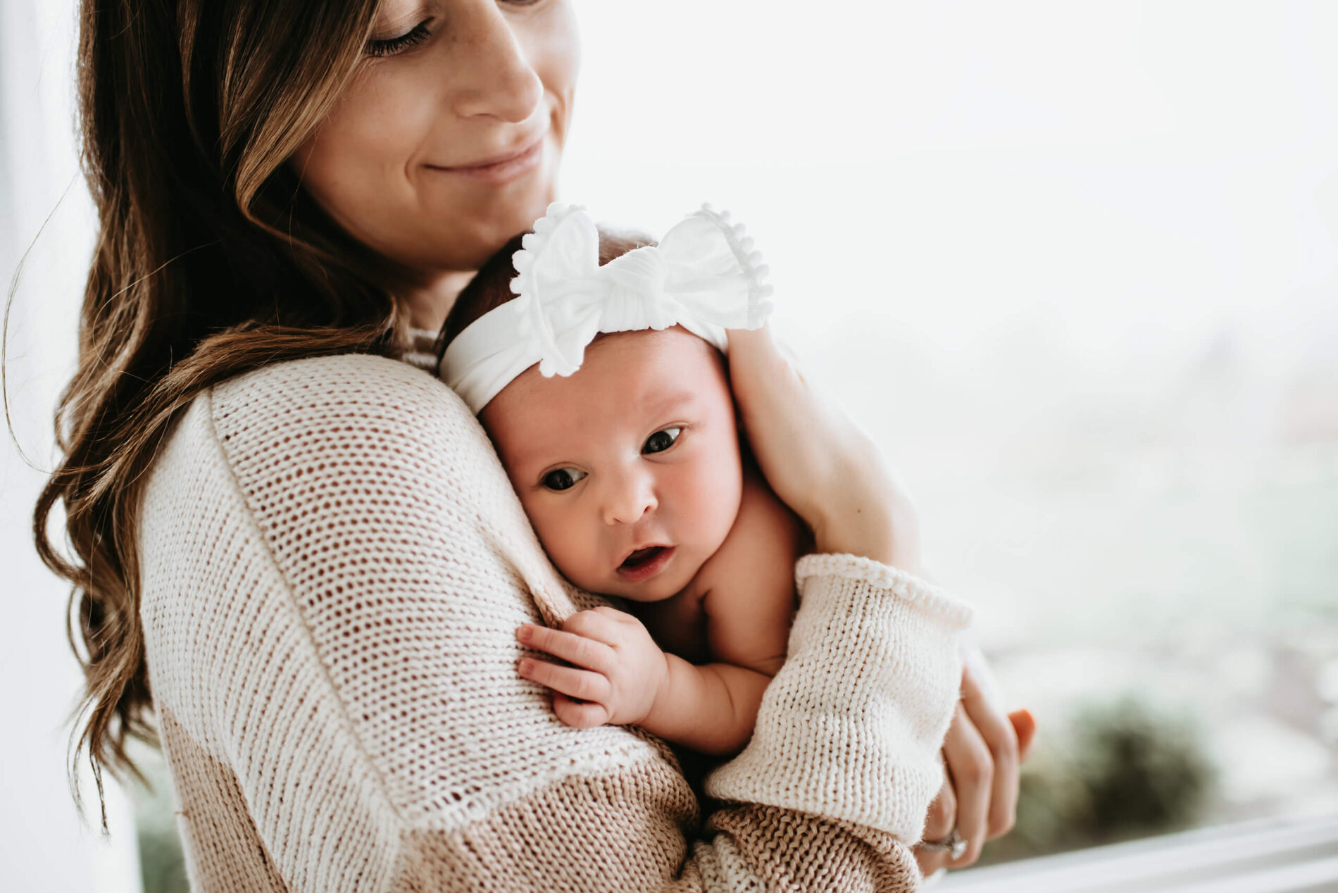 Awake newborn girl peacefully resting on mom's chest