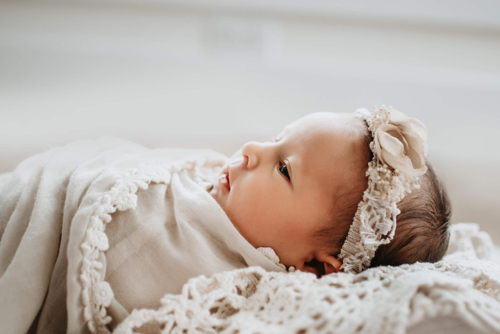 A close-up on newborn's face during an in-home photo shoot