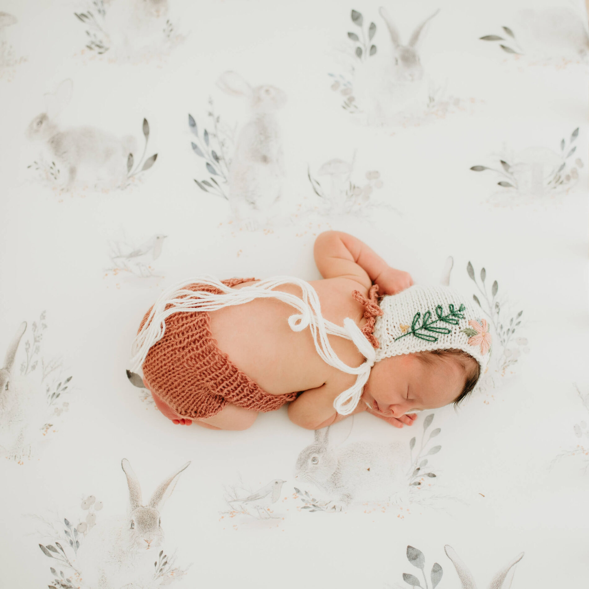 A newborn girl peacefully sleeping in her crib