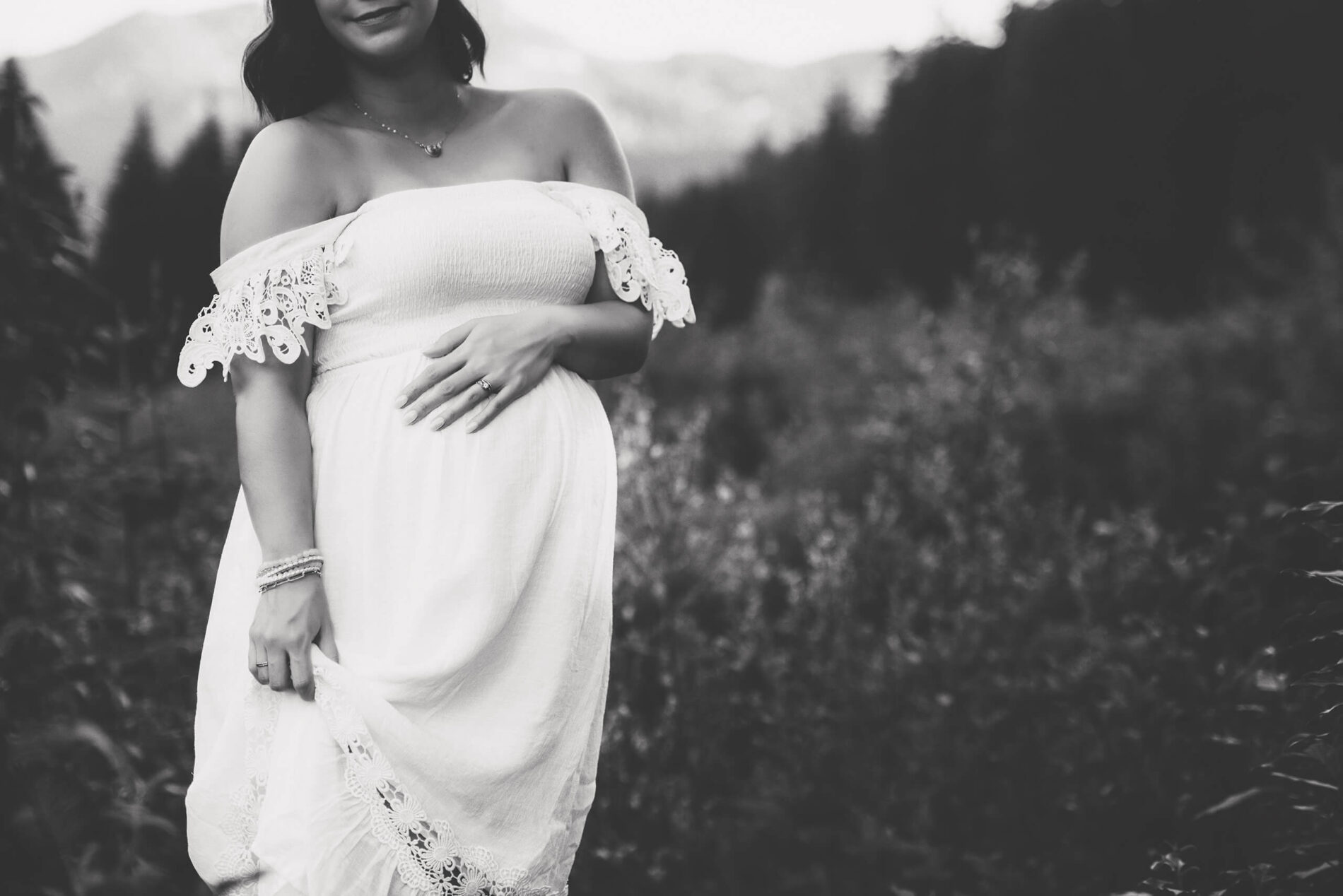 Black and white photo of a pregnant woman with a focus on her stomach