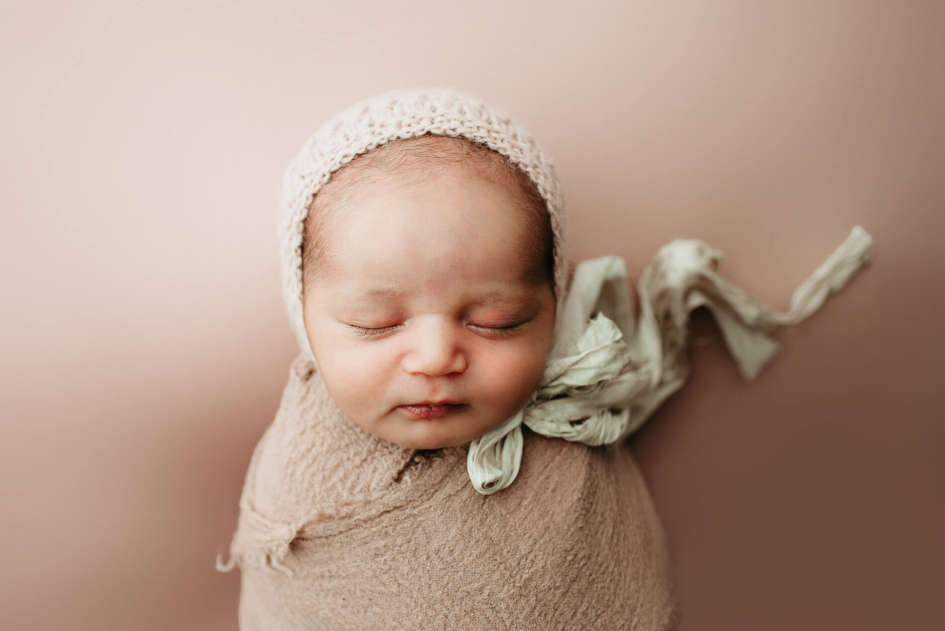 Beautifully captured sleeping newborn girl wrapped and wearing a hat