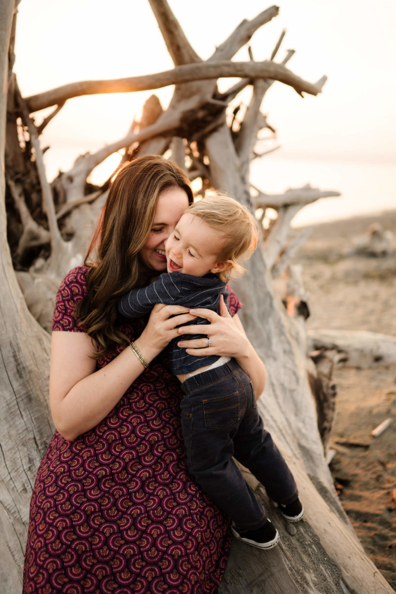 Seattle family photo shoot, mom and young son laughing and hugging at the beach