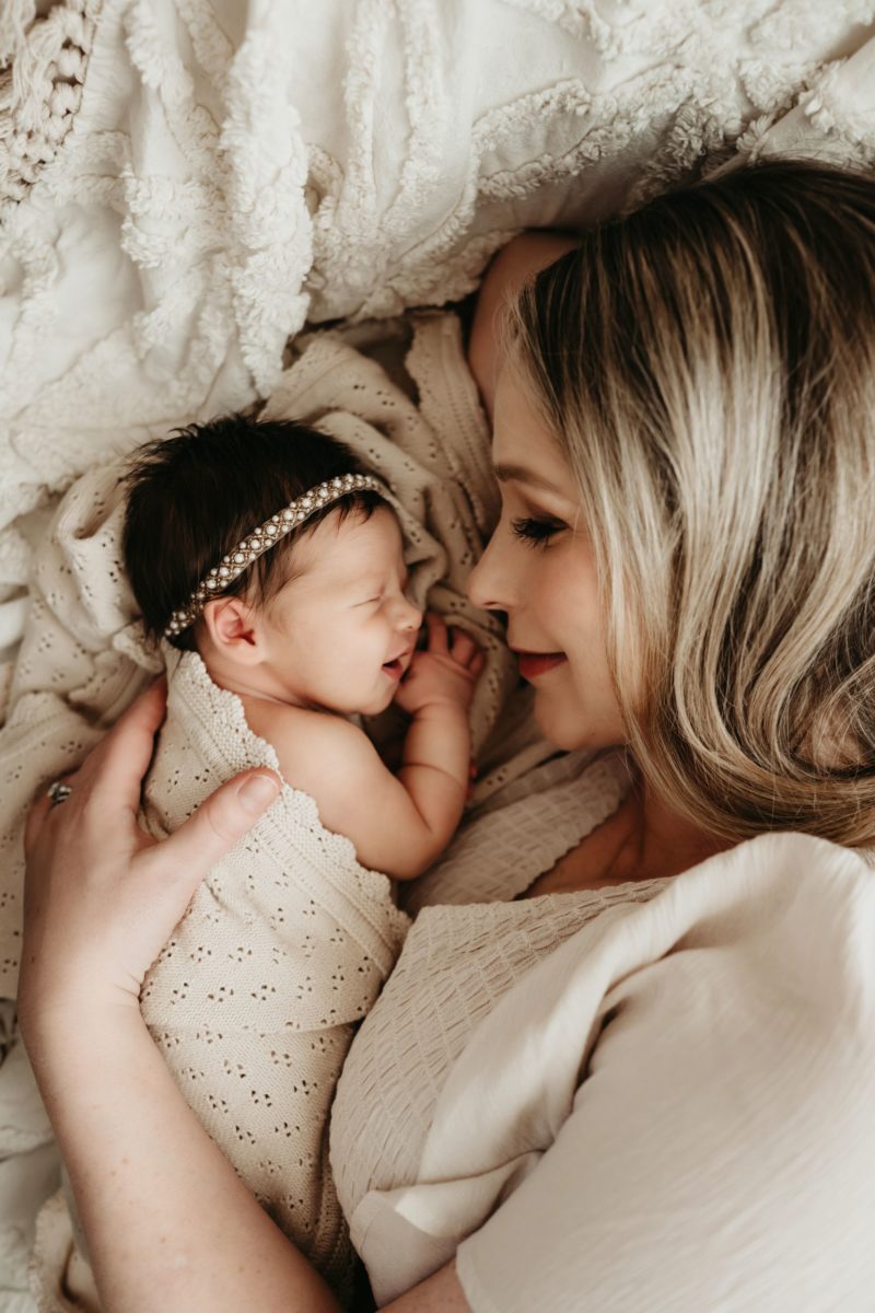 Mom lying close to her newborn girl, smiling