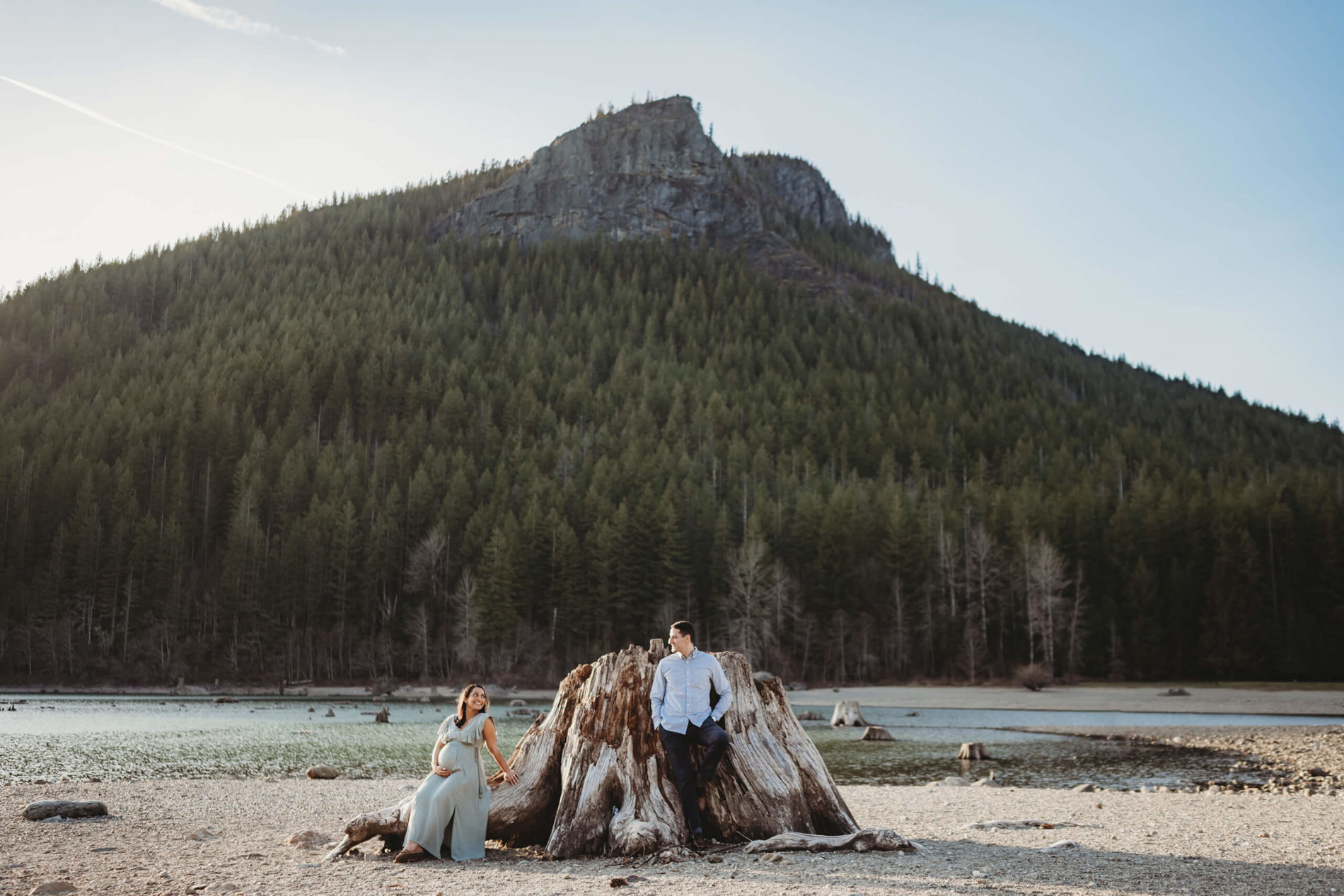 A masterfully posed maternity portrait of a husband and wife on the beach of Rattlesnake Lake in North Bend, WA