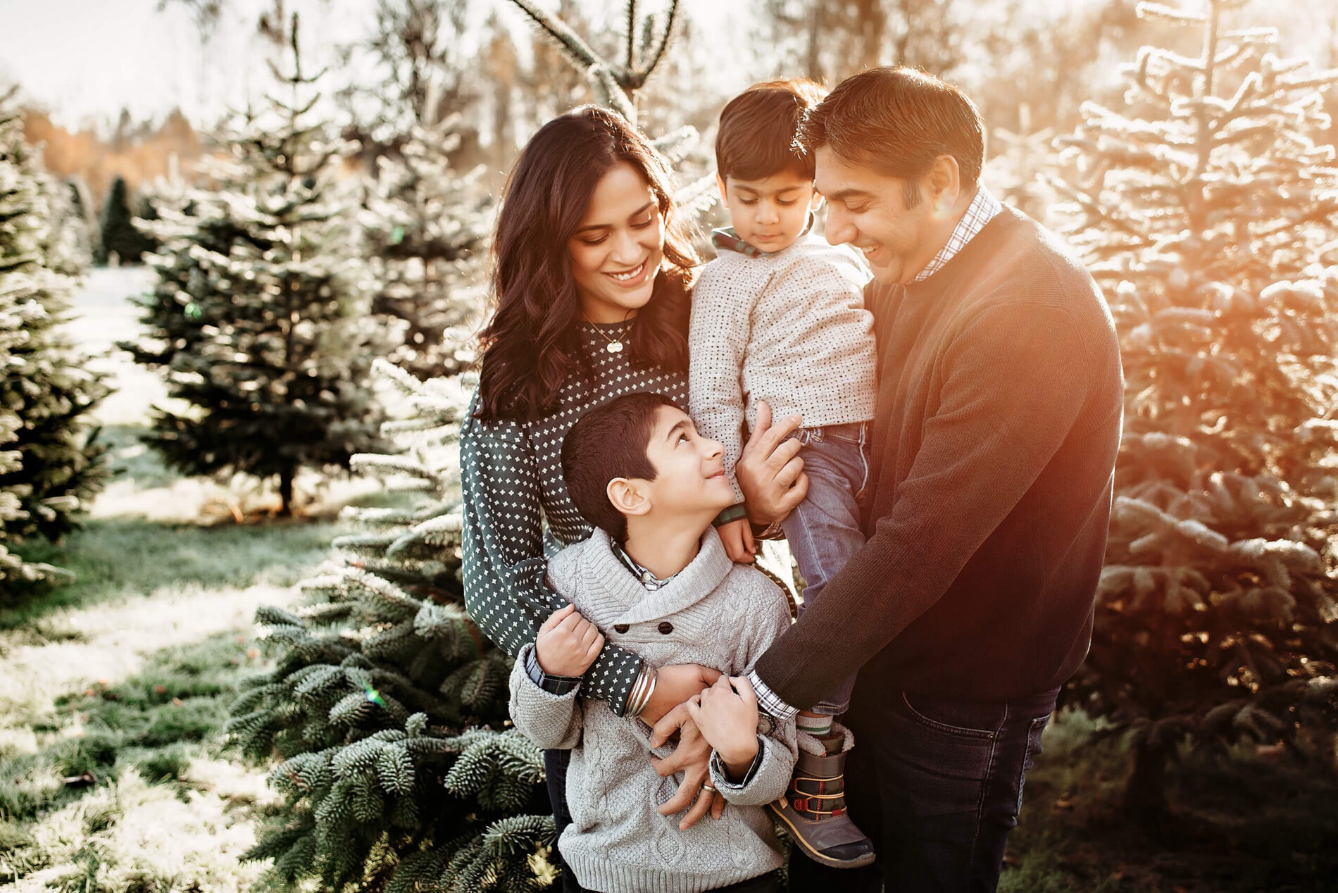 Seattle holiday family photography, mom, dad and two sons hugging at a Christmas Tree farm in Redmond, WA