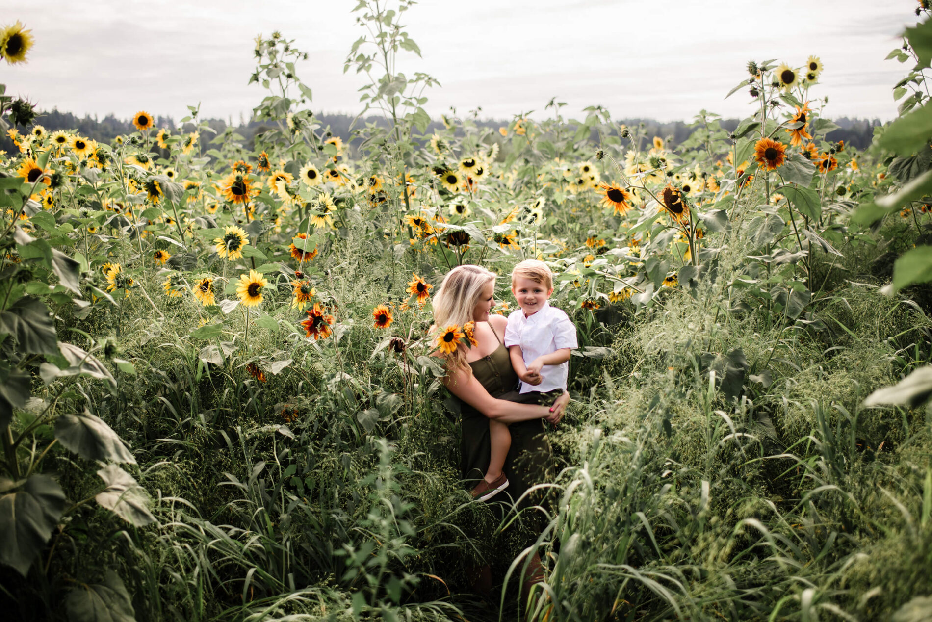 Mom and holding her son in a stunning sunflower field