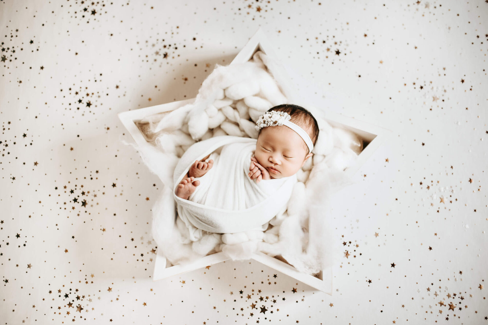 A beautiful newborn girl wrapped in white blankets