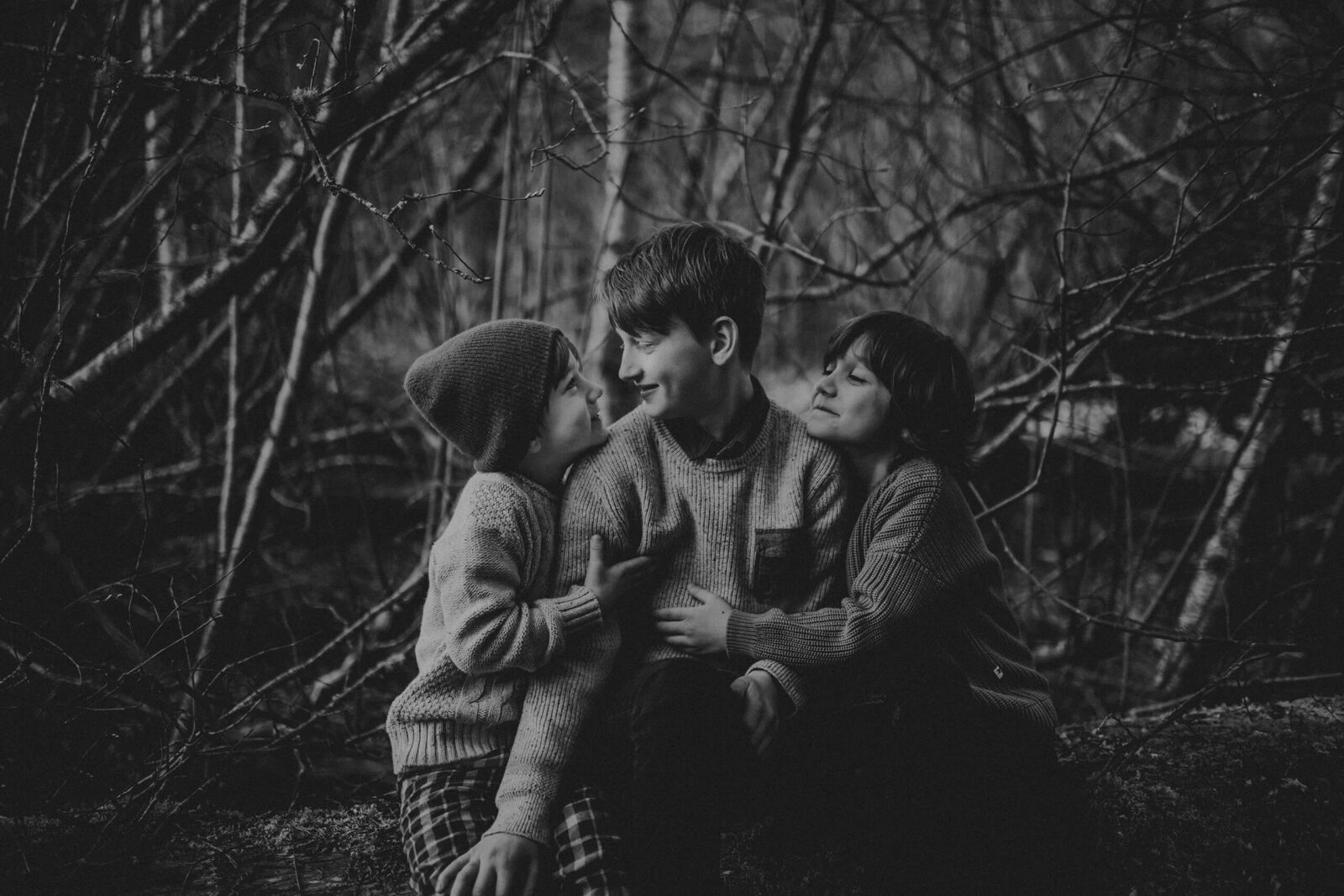 Three brothers hugging in the outdoors