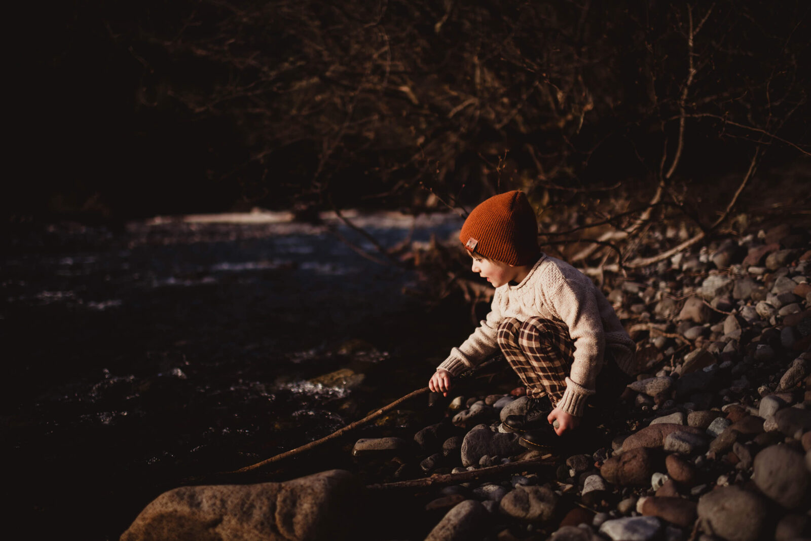 A boy playing next to a river
