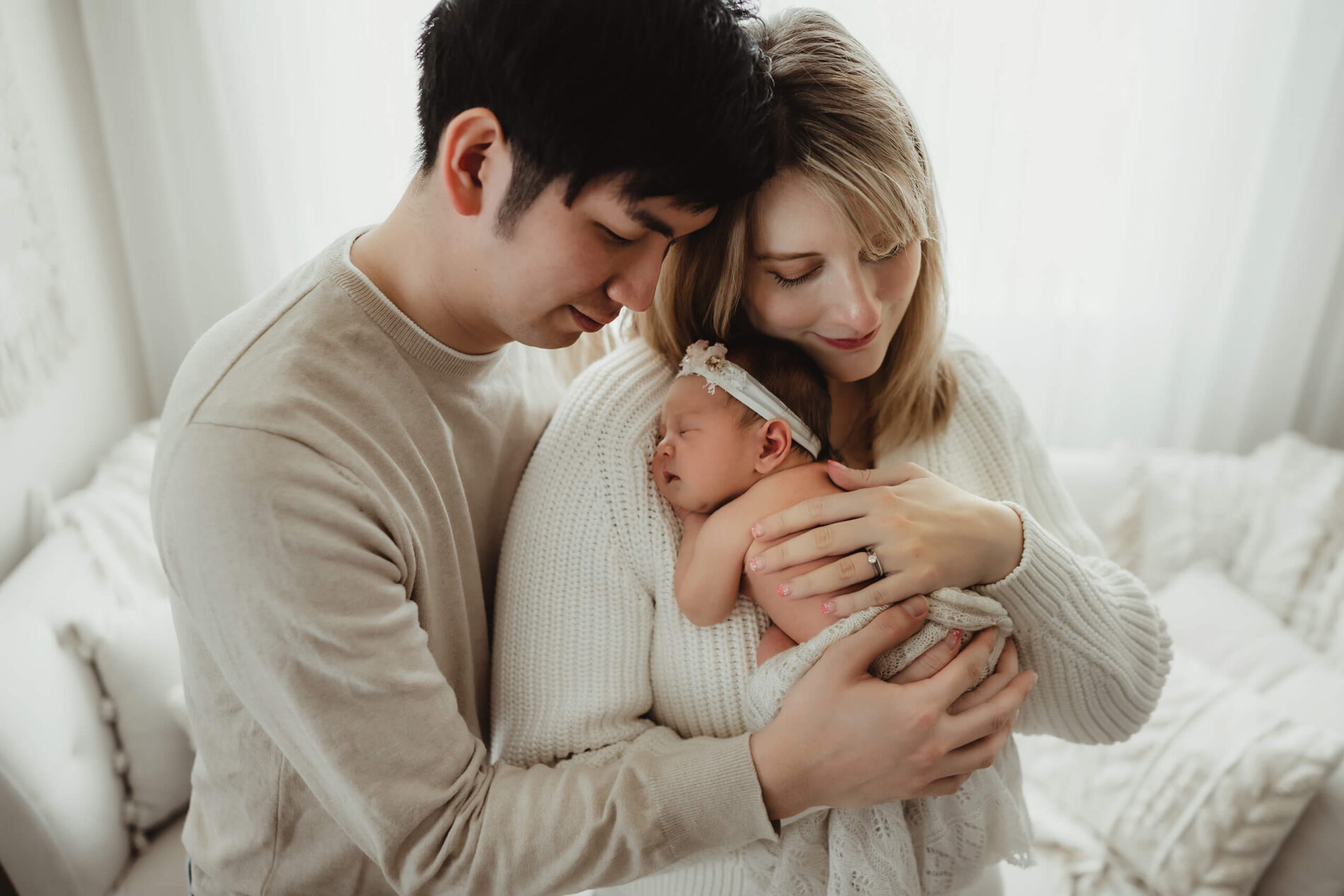 Man hugging his wife and newborn daughter