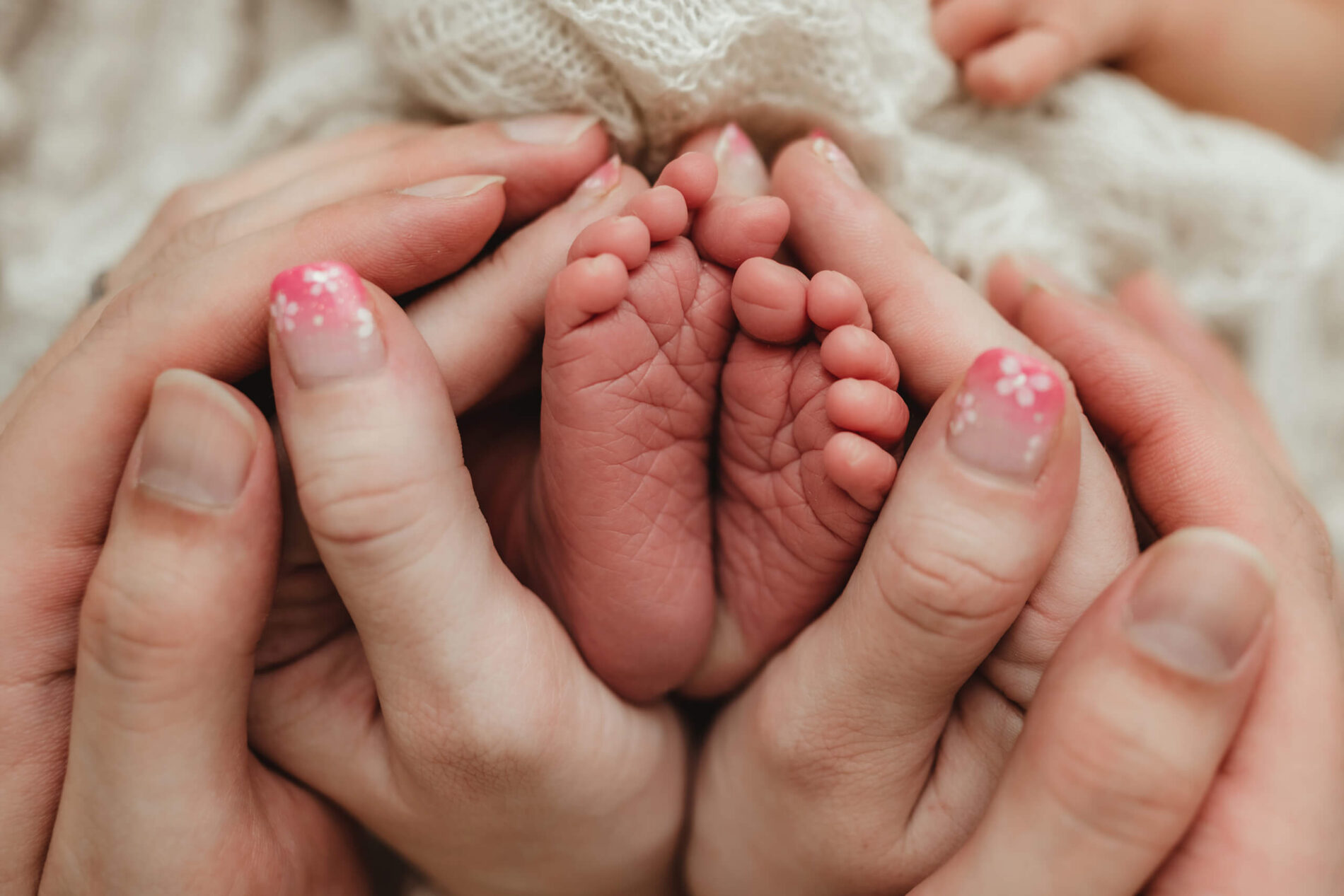 A close-up of newborn's feet in parent's arms