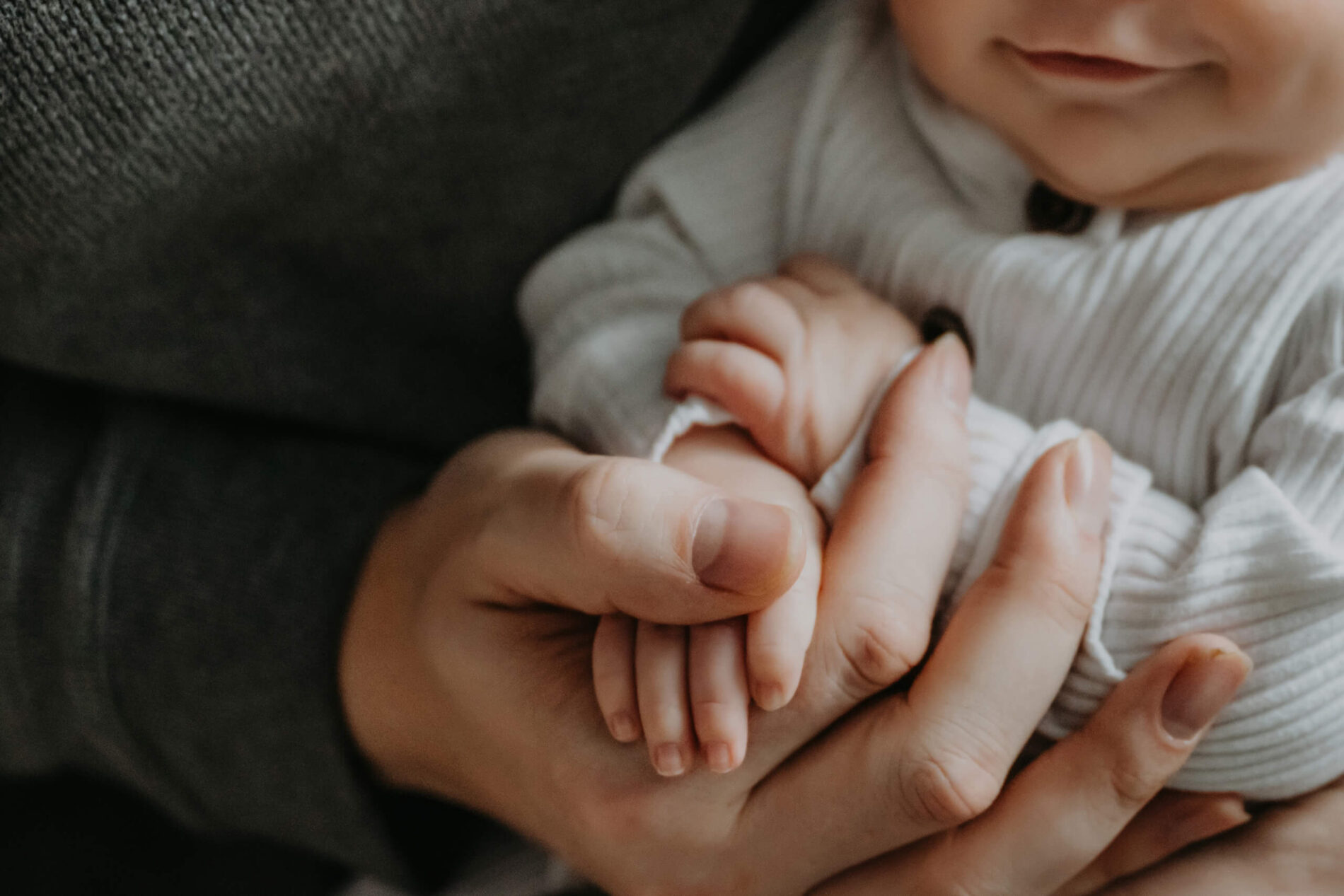 A close-up on baby's arms being hugged by dad