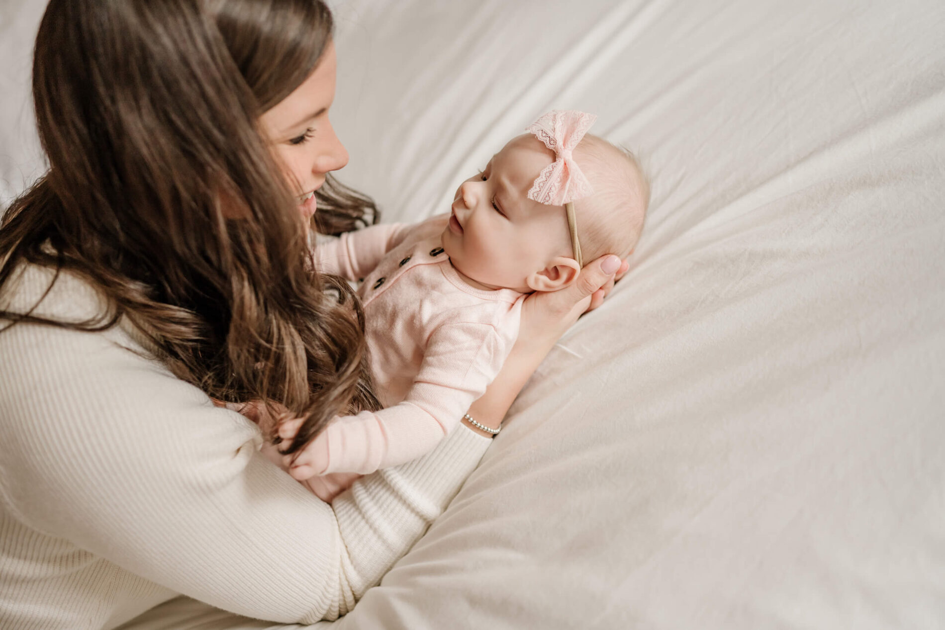 A baby girl in her mother's arms, smiling