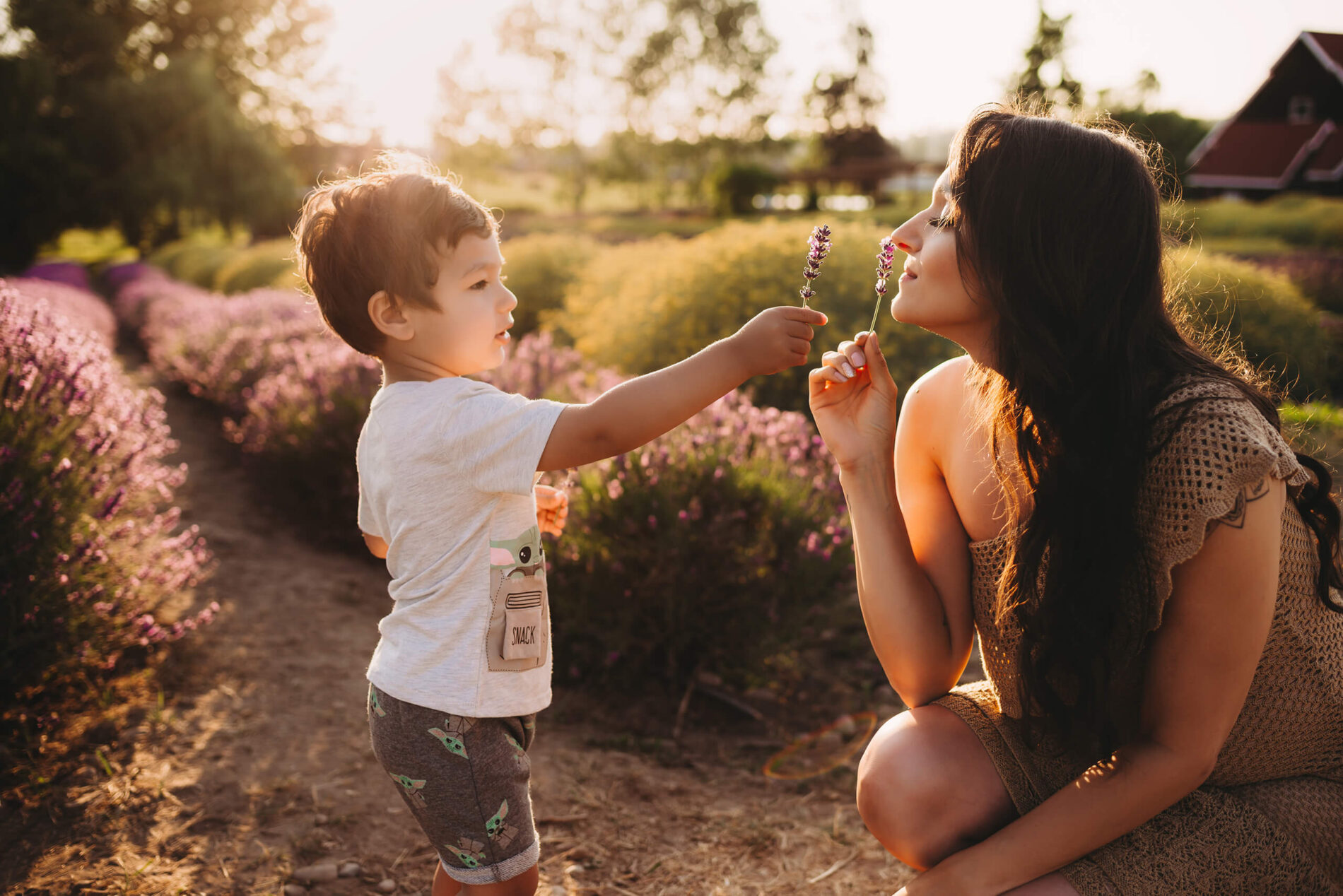 Young boy showing a lavender flower to his mom