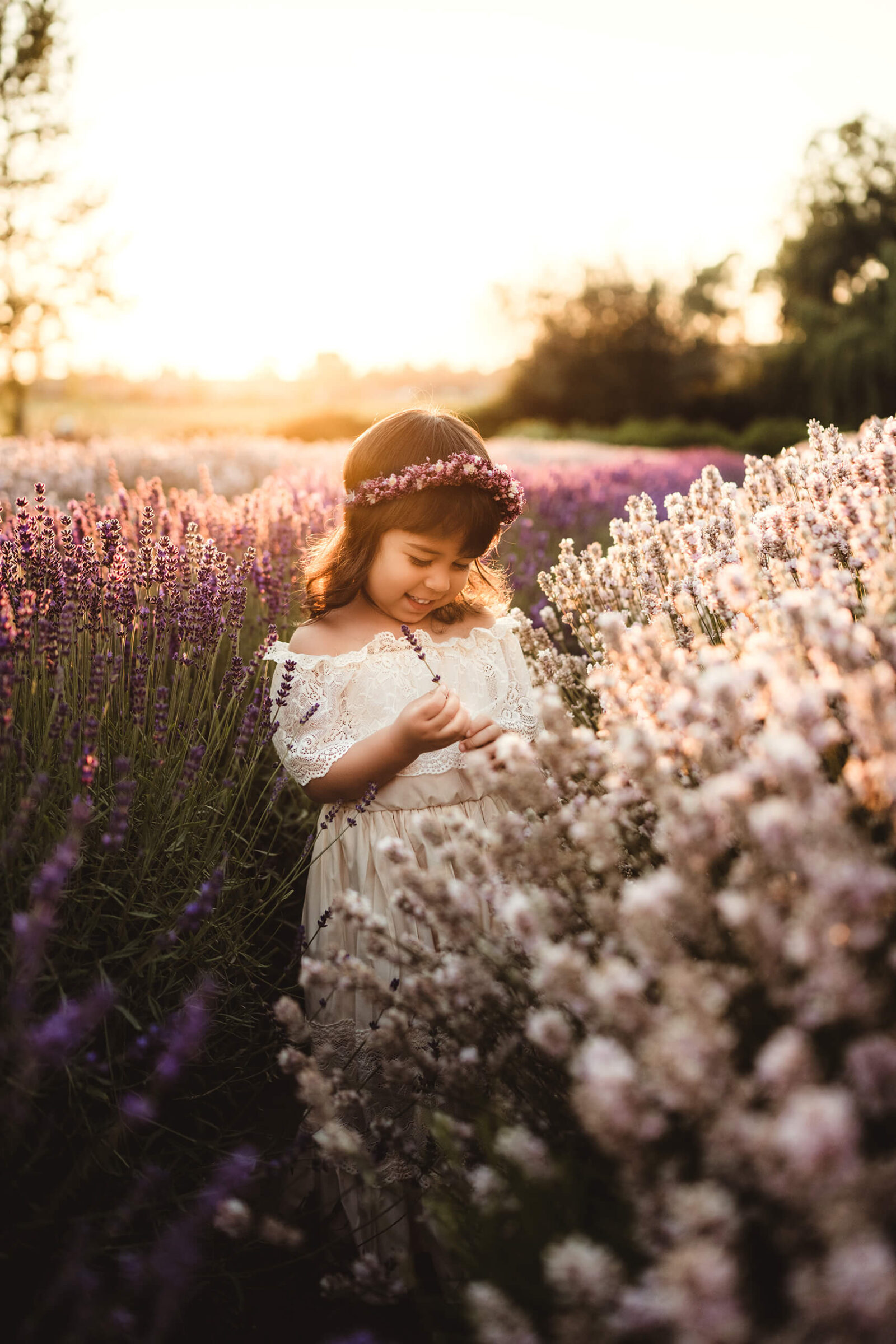 A smiling girl in a white dress standing in a beautiful lavender field