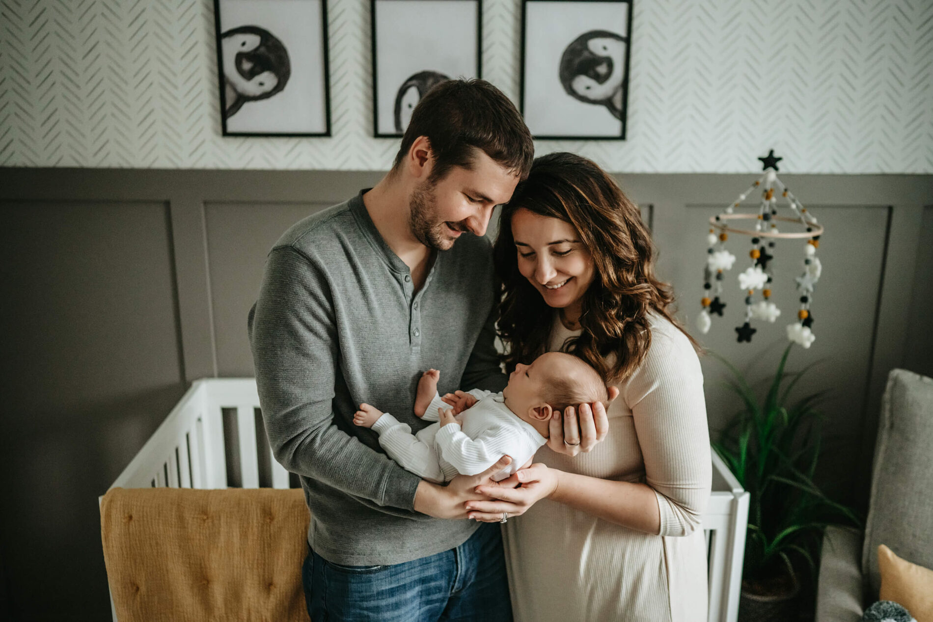 Mom and dad holding their newborn son in his nursery