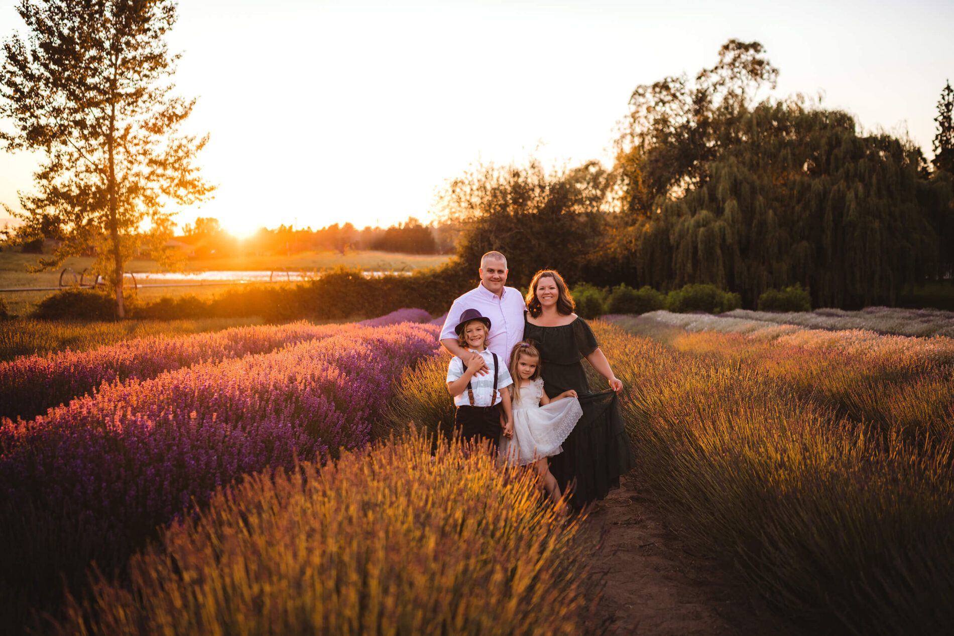 Mom, dad, with son and daughter posing in a lavender field during stunning sunset