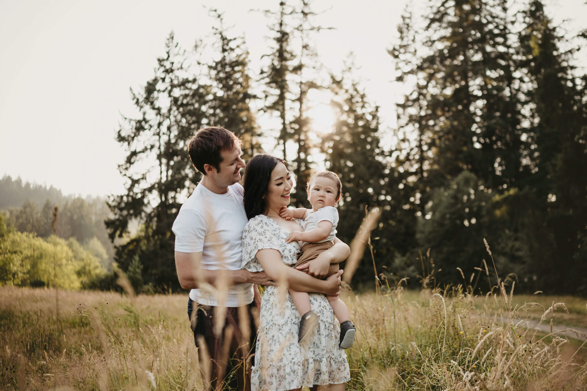 Mom, dad, and toddler boy having fun in a park