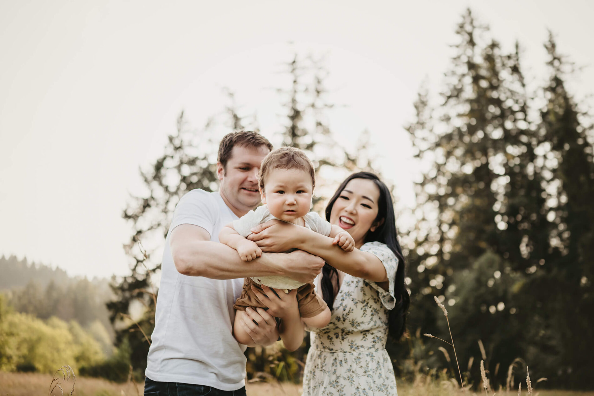 Mom and dad playing with their son in a park