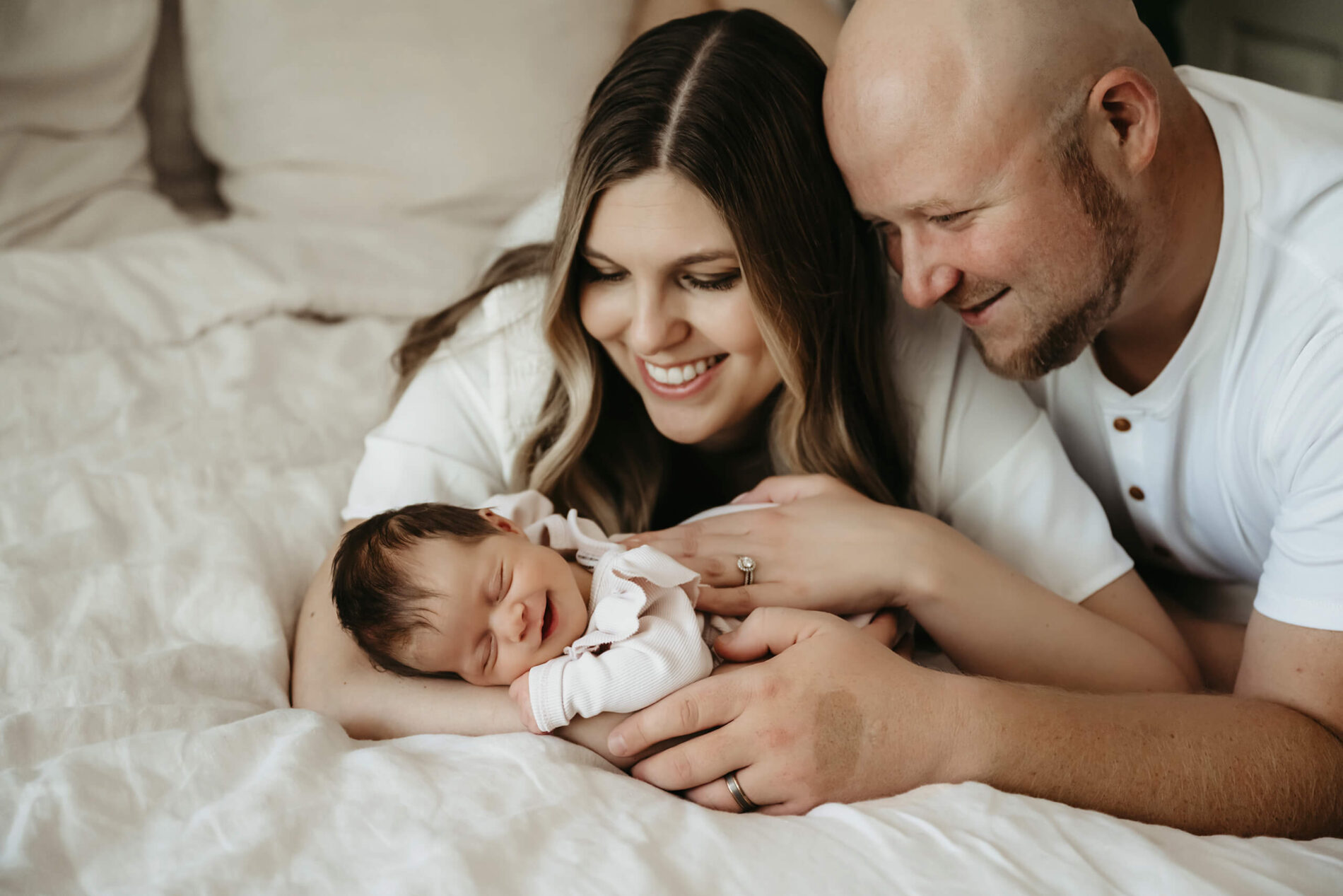Seattle area in-home lifestyle newborn photography of mom, dad and their smiling newborn daughter