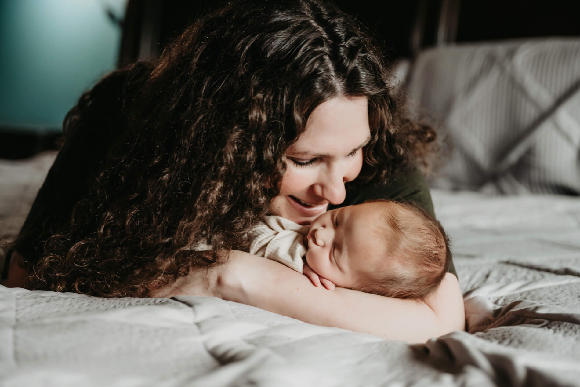 Unique in-home newborn photography of mom cuddling with her newborn son