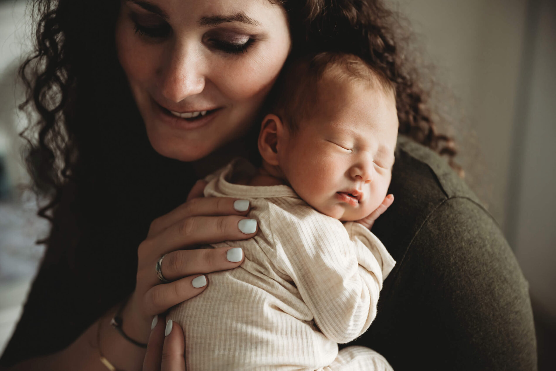 Unique in-home newborn photography of mom cuddling with her newborn son