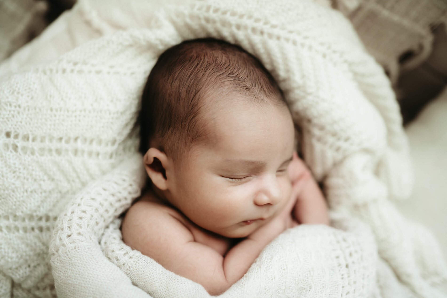 Newborn photography session: cozily-wrapped sleeping newborn boy