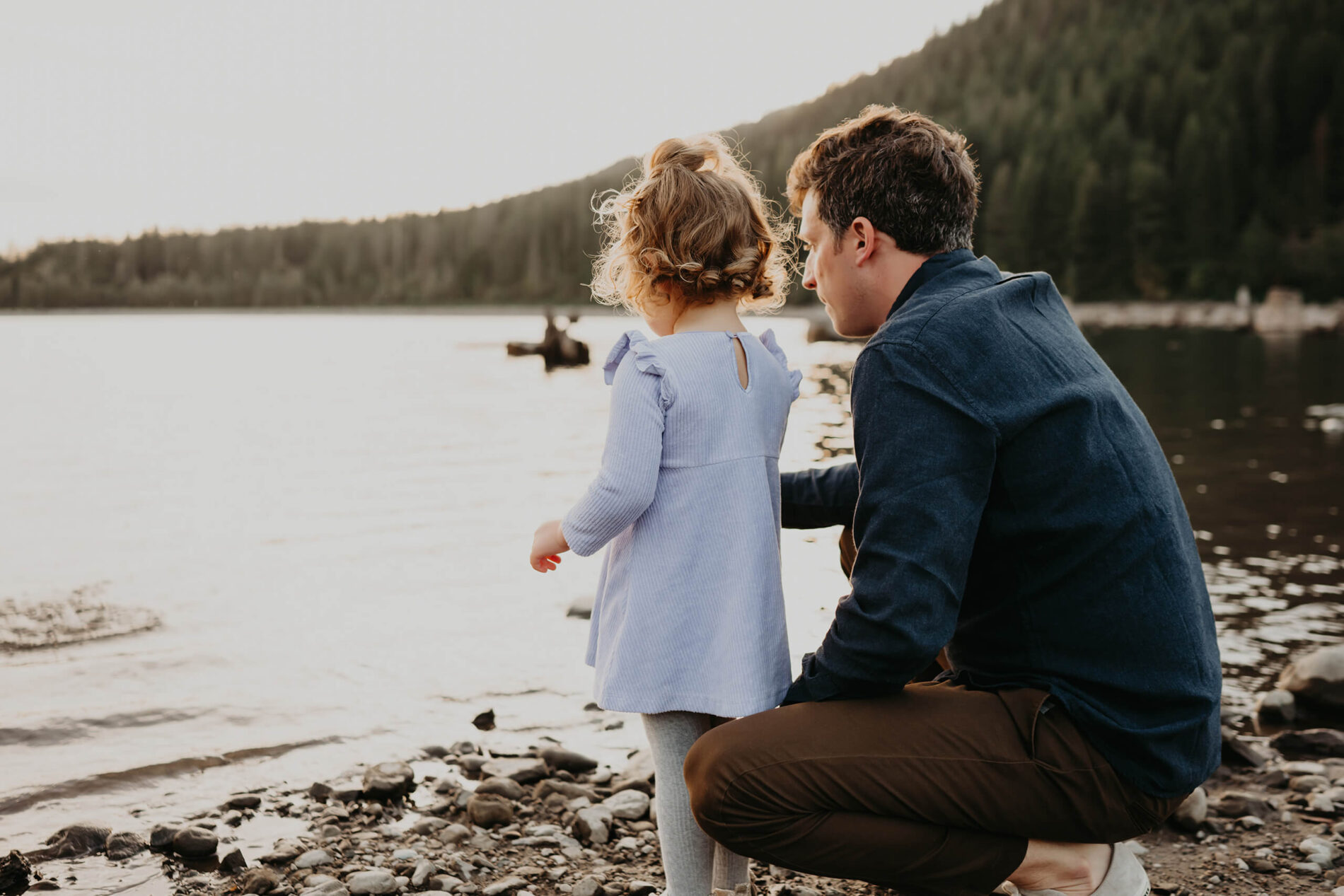 Family photo session of dad with his daughter standing on a beach at Rattlesnake Lake