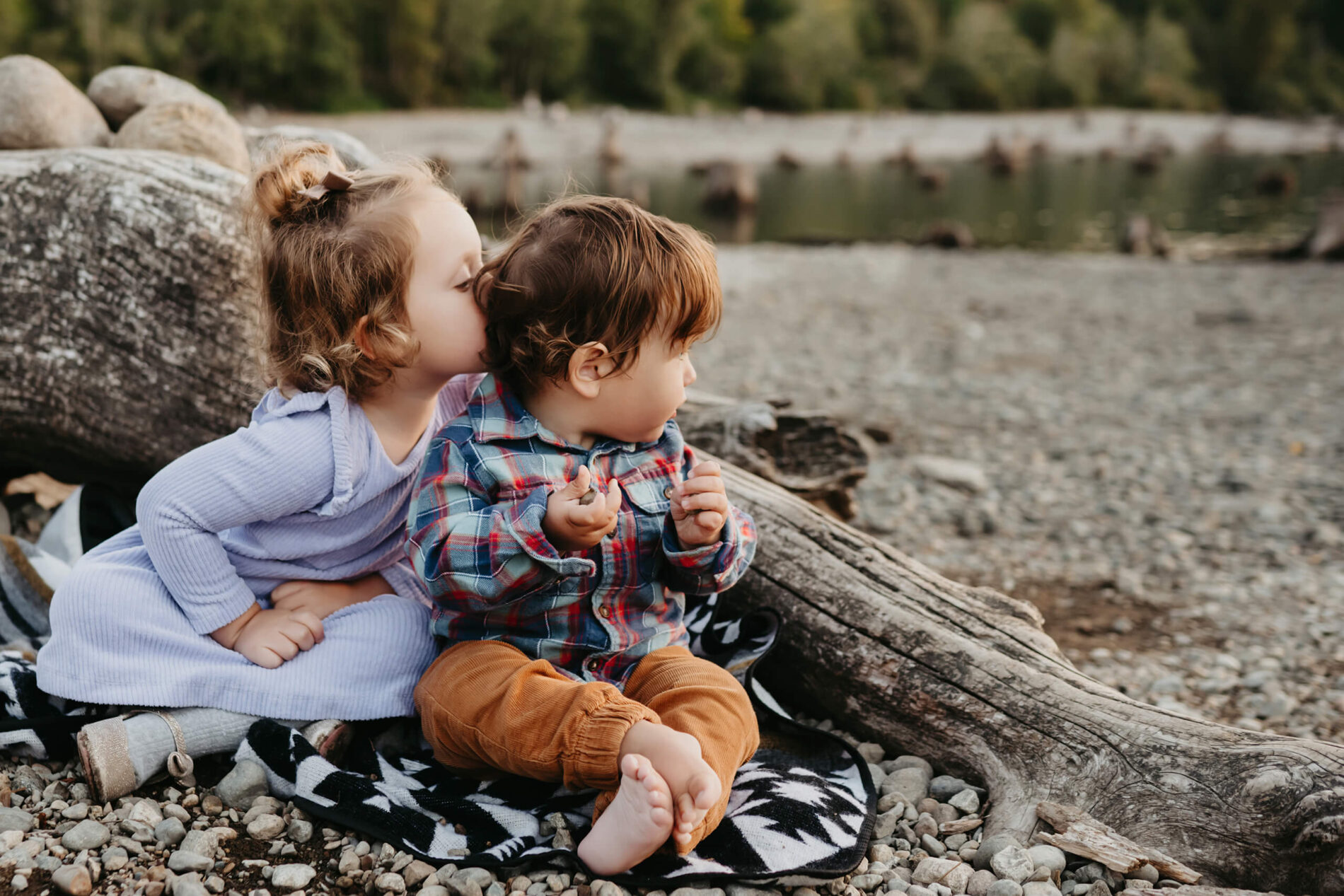 Family portrait of siblings with sister kissing her brother on a beach at Rattlesnake Lake