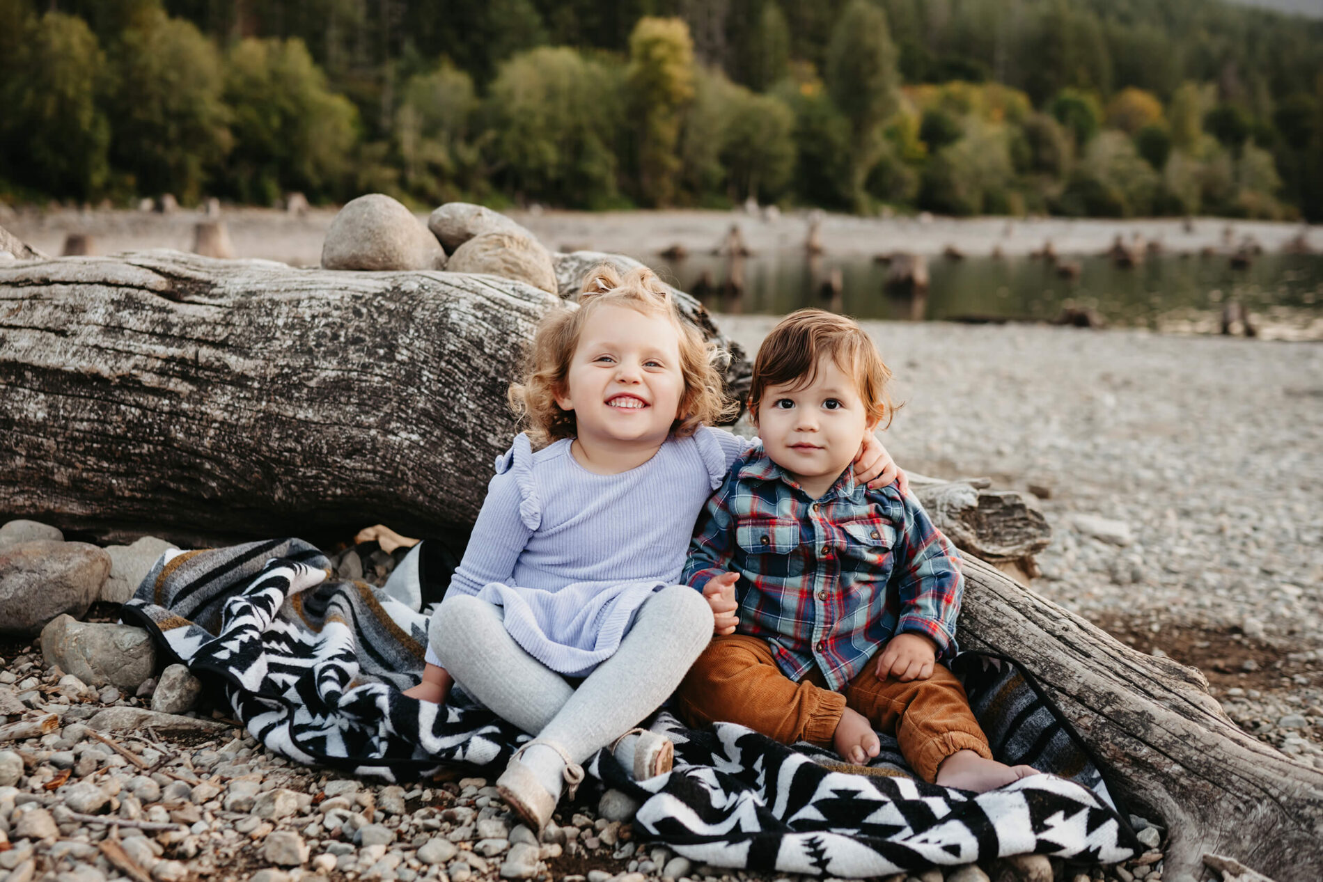 Family photo session with two small siblings sitting on a beach at Rattlesnake Lake