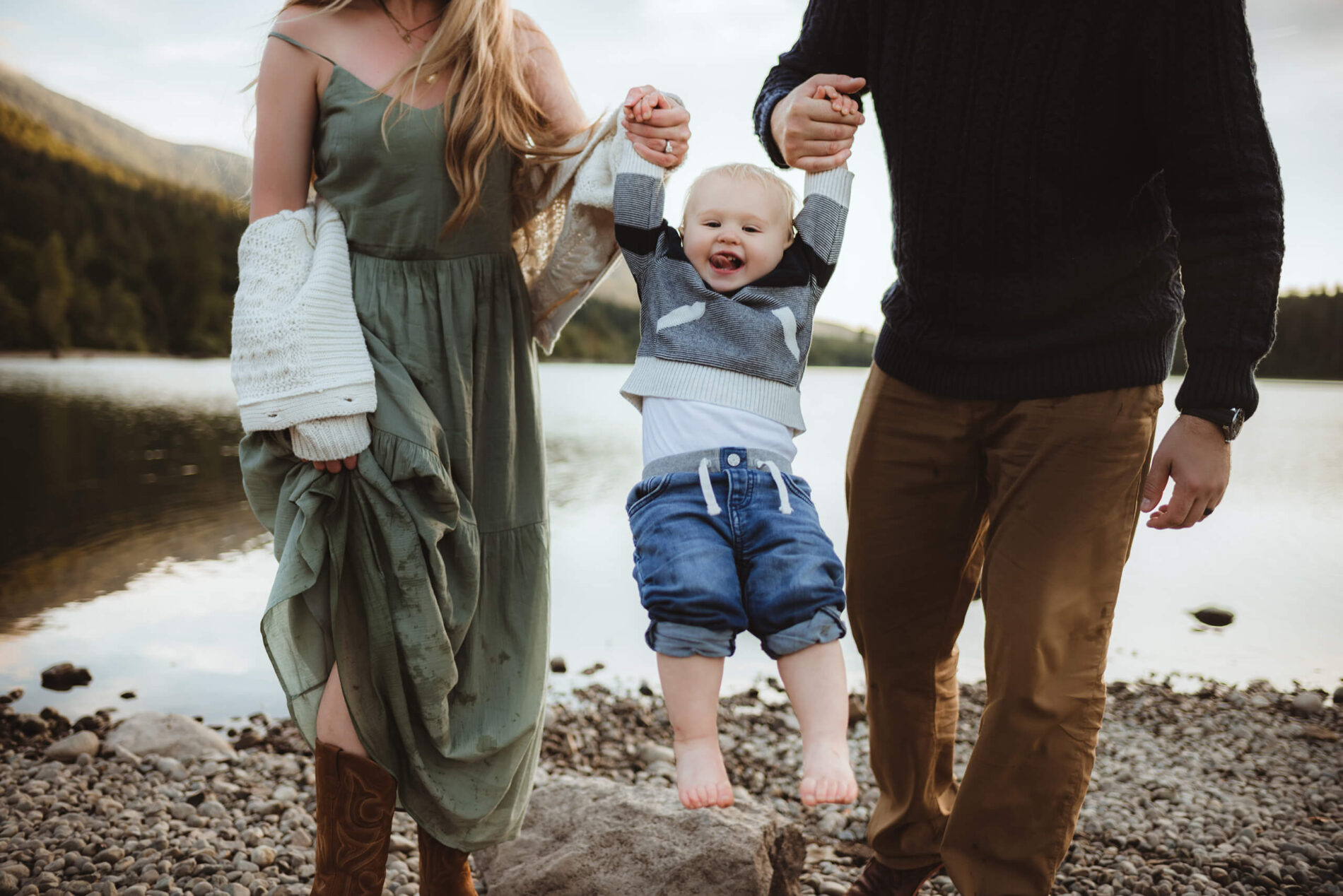A moment during family photo shoot of mom and dad playing with their toddler son
