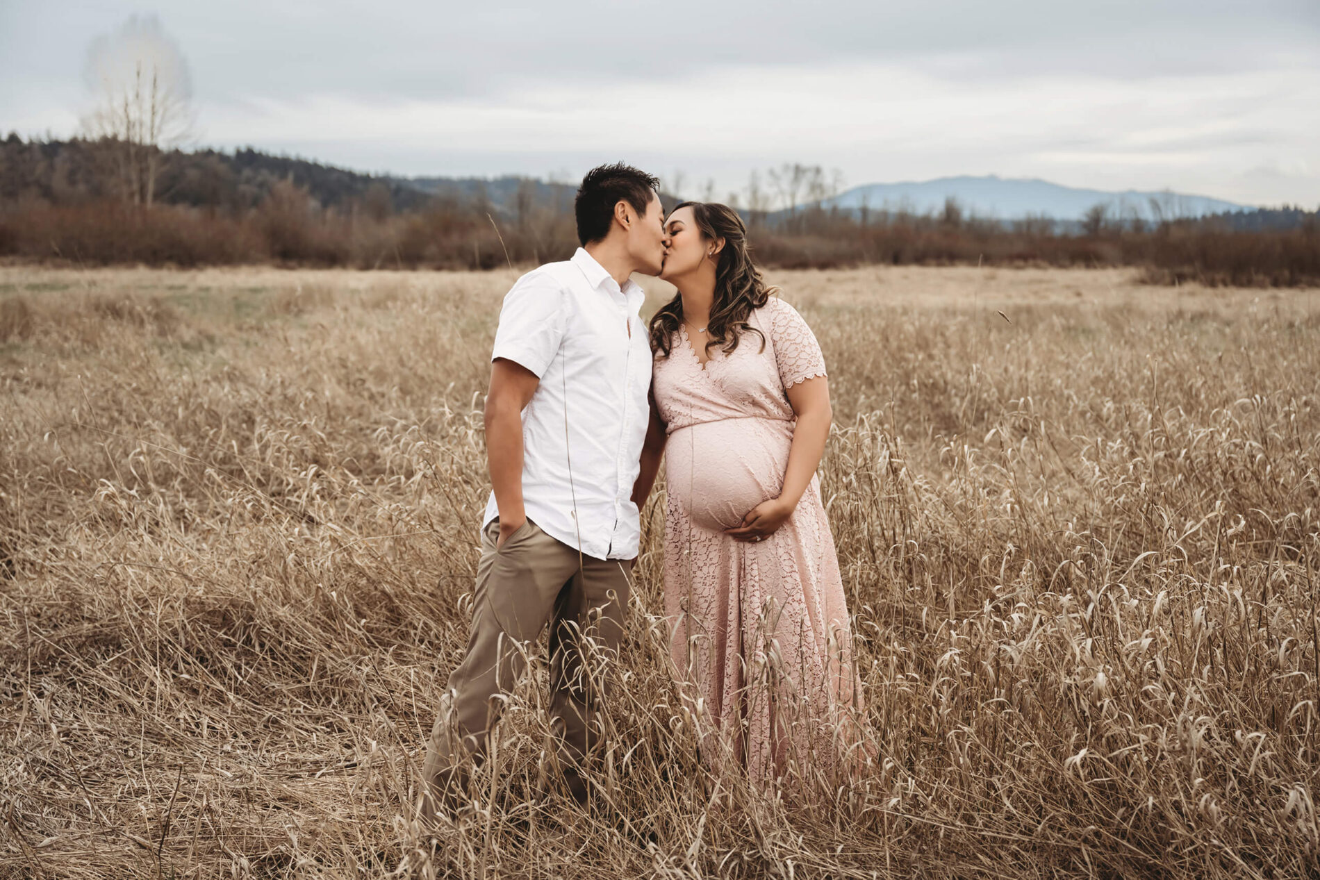 Young couple kissing during a maternity photo session in the Seattle area