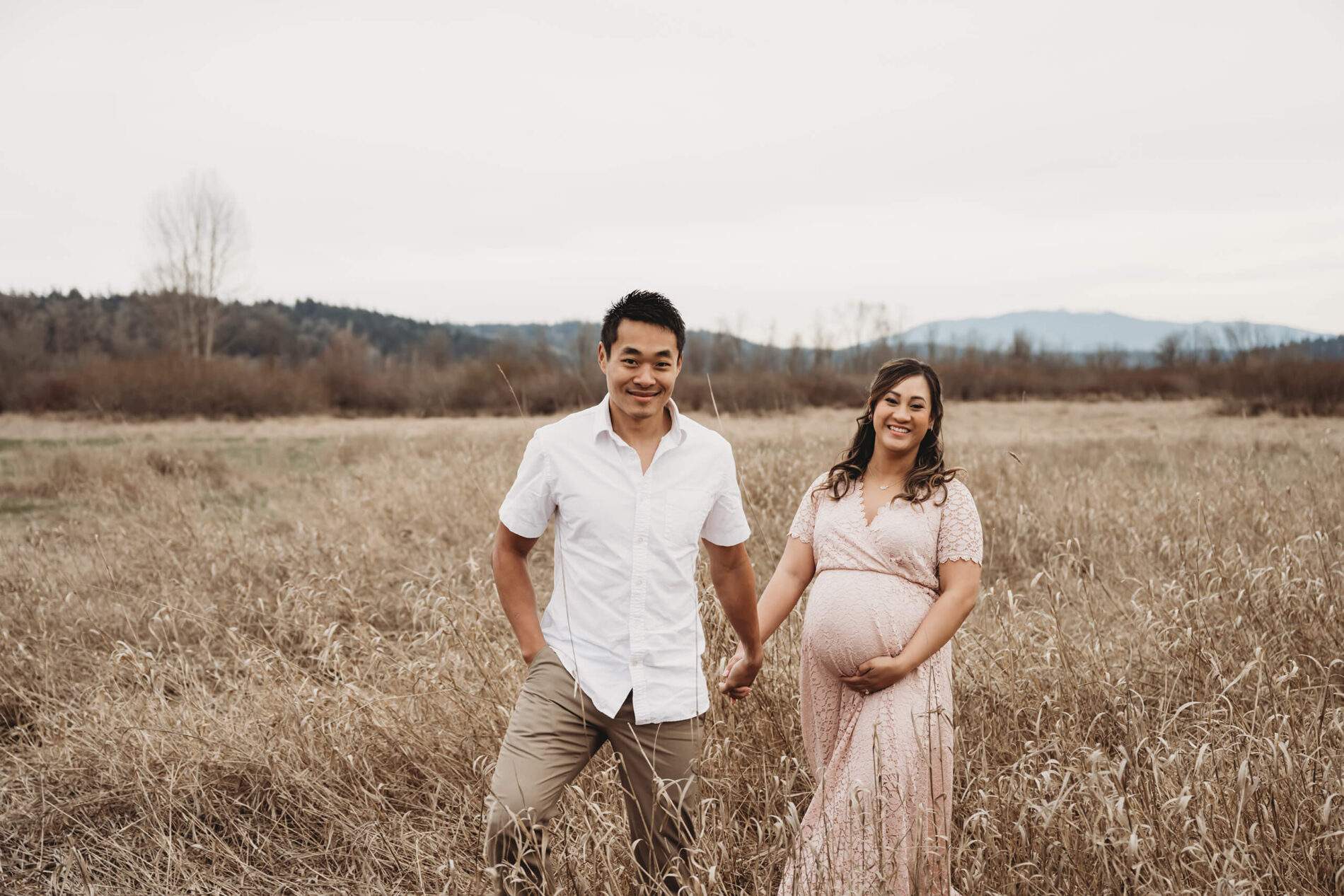 Young couple holding hands during a maternity photo session in the Seattle area