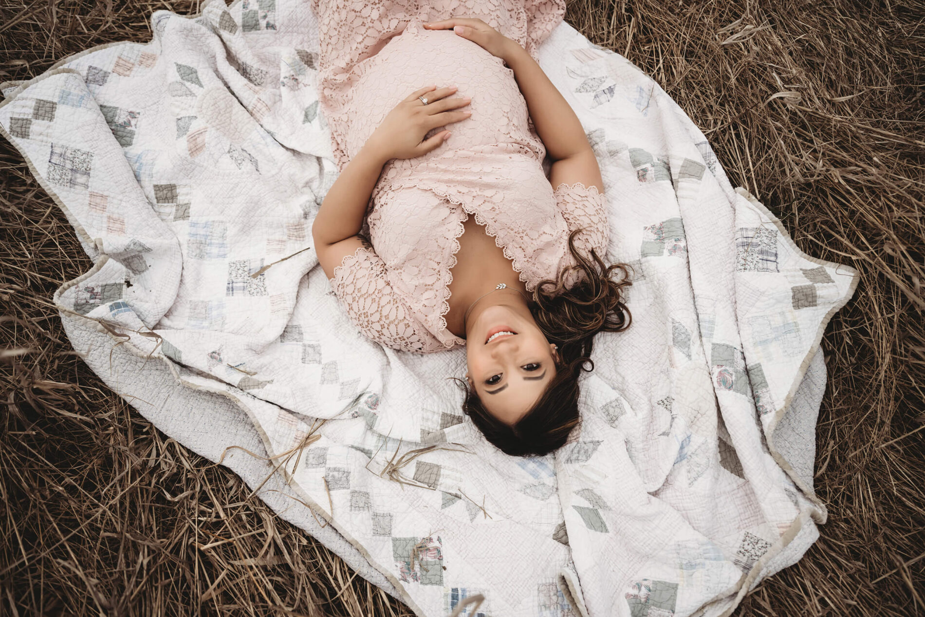 Maternity photo of a young woman lying in a field in the Seattle area during winter