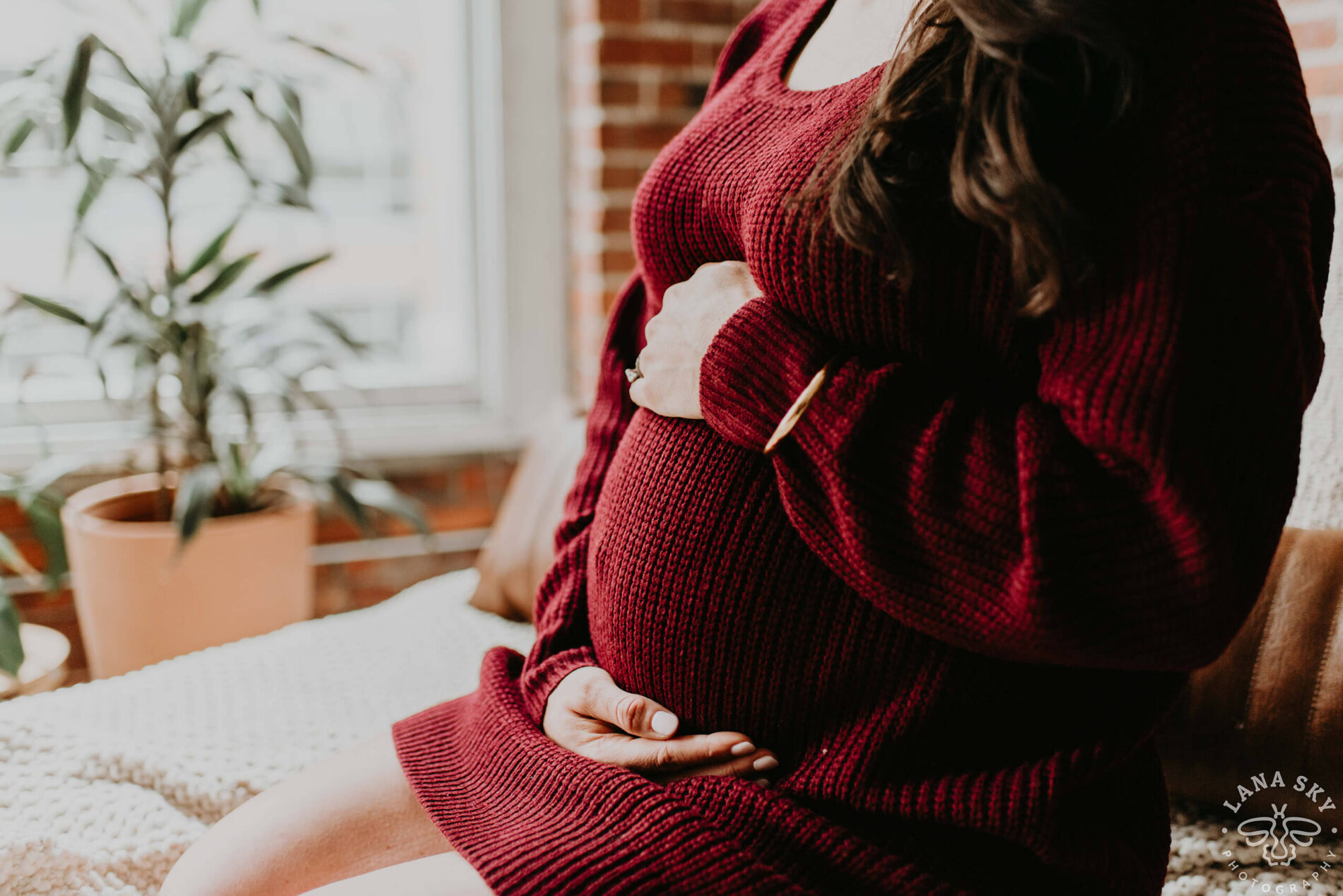 A studio pose on the bed during a maternity photoshoot