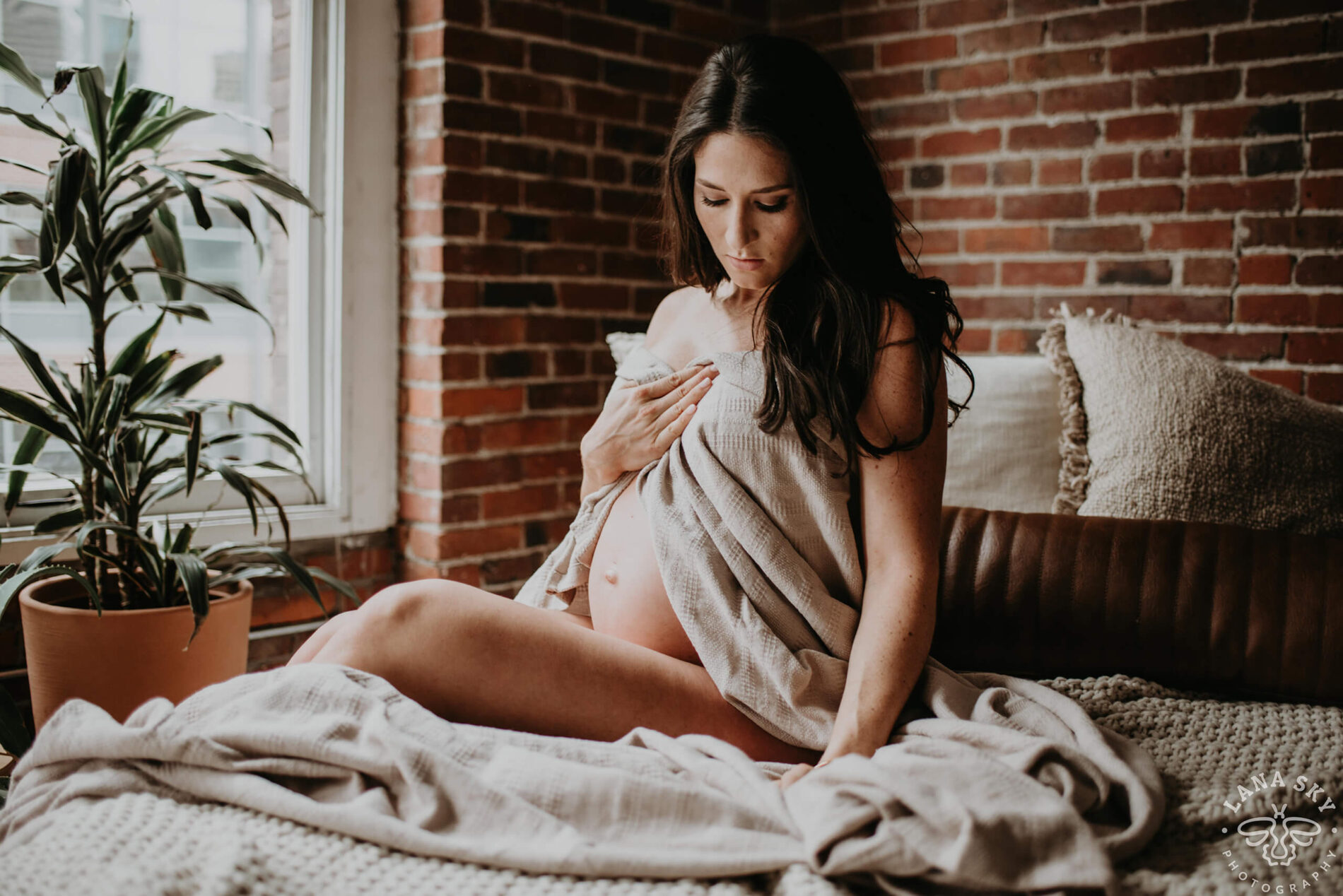 A studio pose on the bed during a maternity photoshoot
