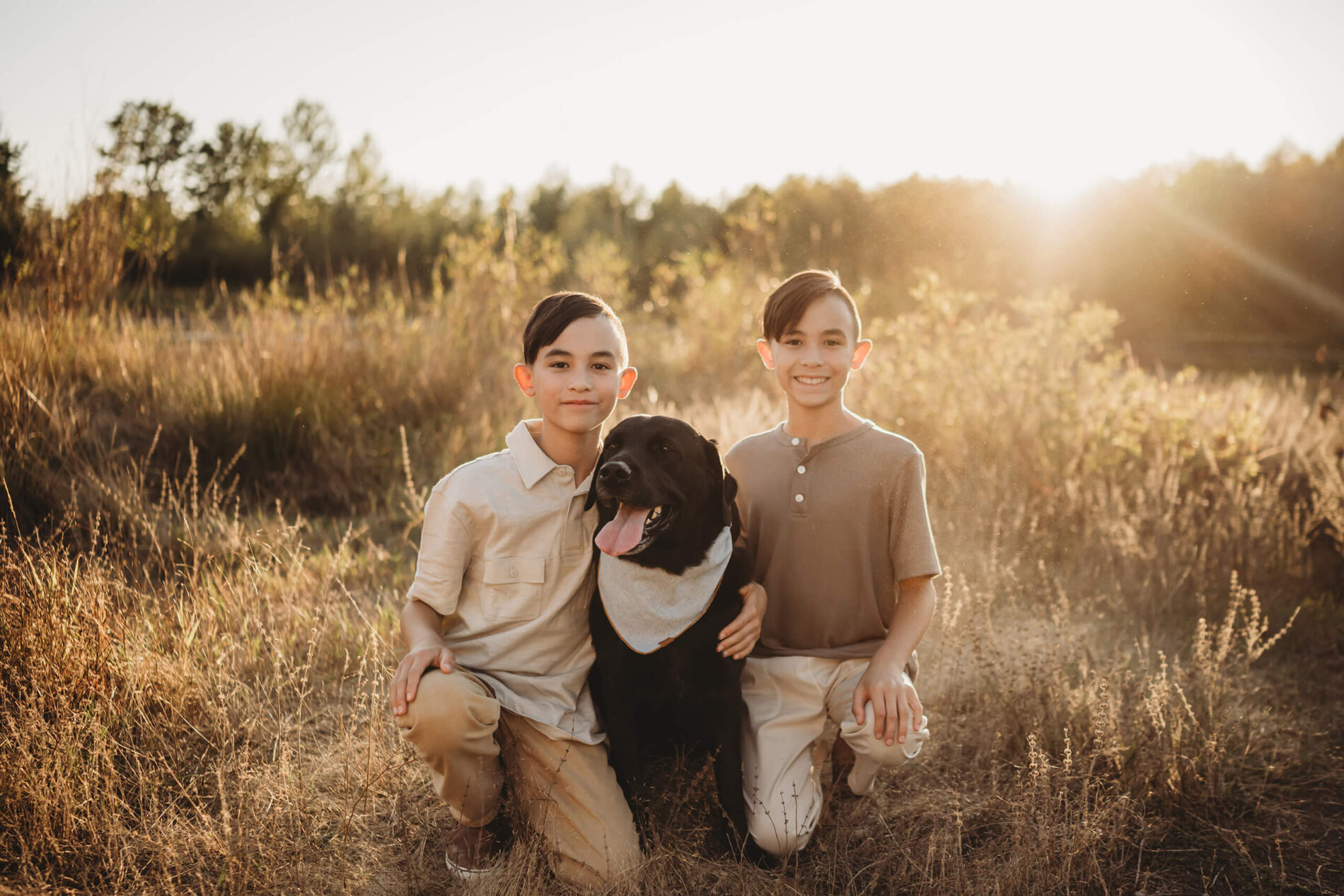 Family portrait with two brothers and their dog in a beautiful sunlit field in Redmond, WA