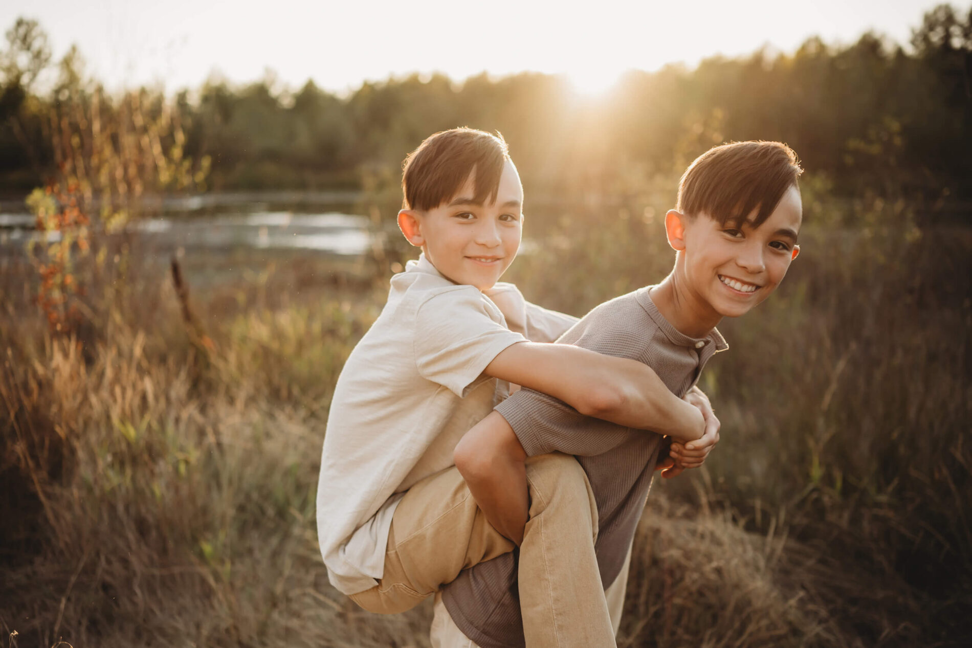 Lifestyle family photography of two brothers in a field during sunset