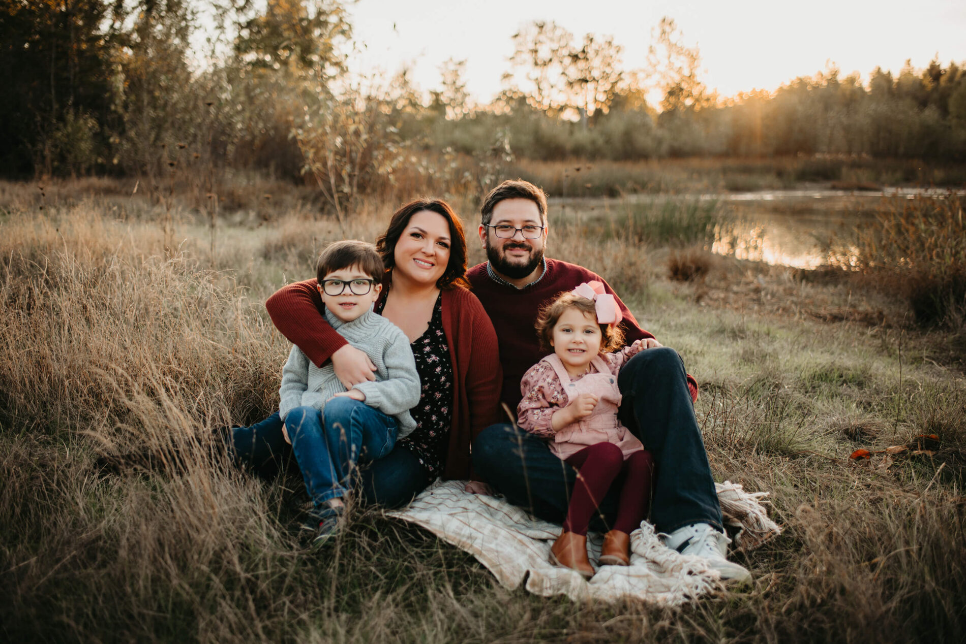 Family photo session in Redmond, WA of mom, dad with two kids in a natural setting with a pond in the background