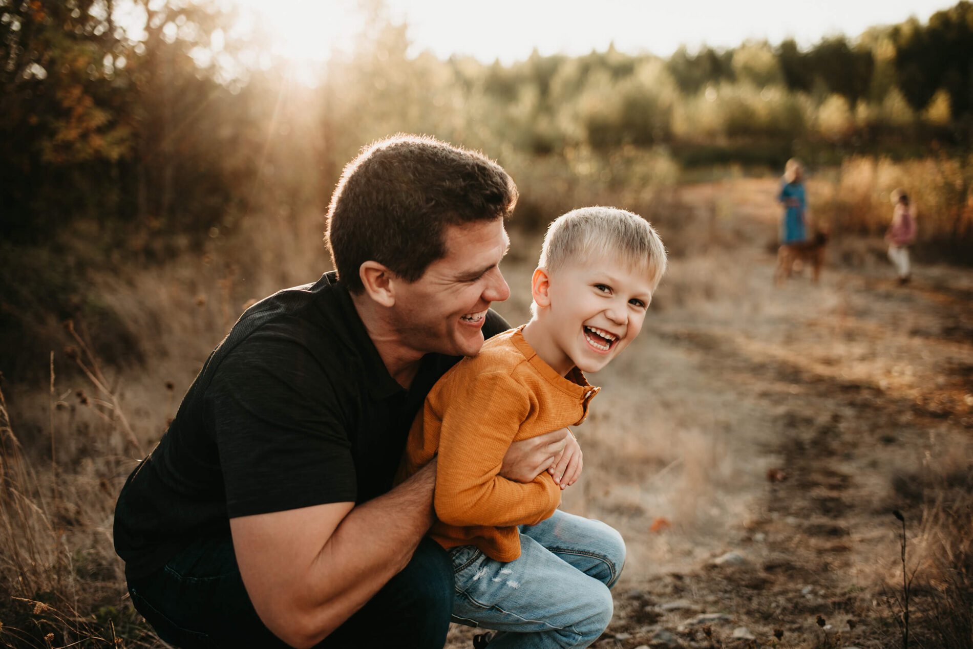 Family lifestyle portrait of a dad playing with his son, both laughing