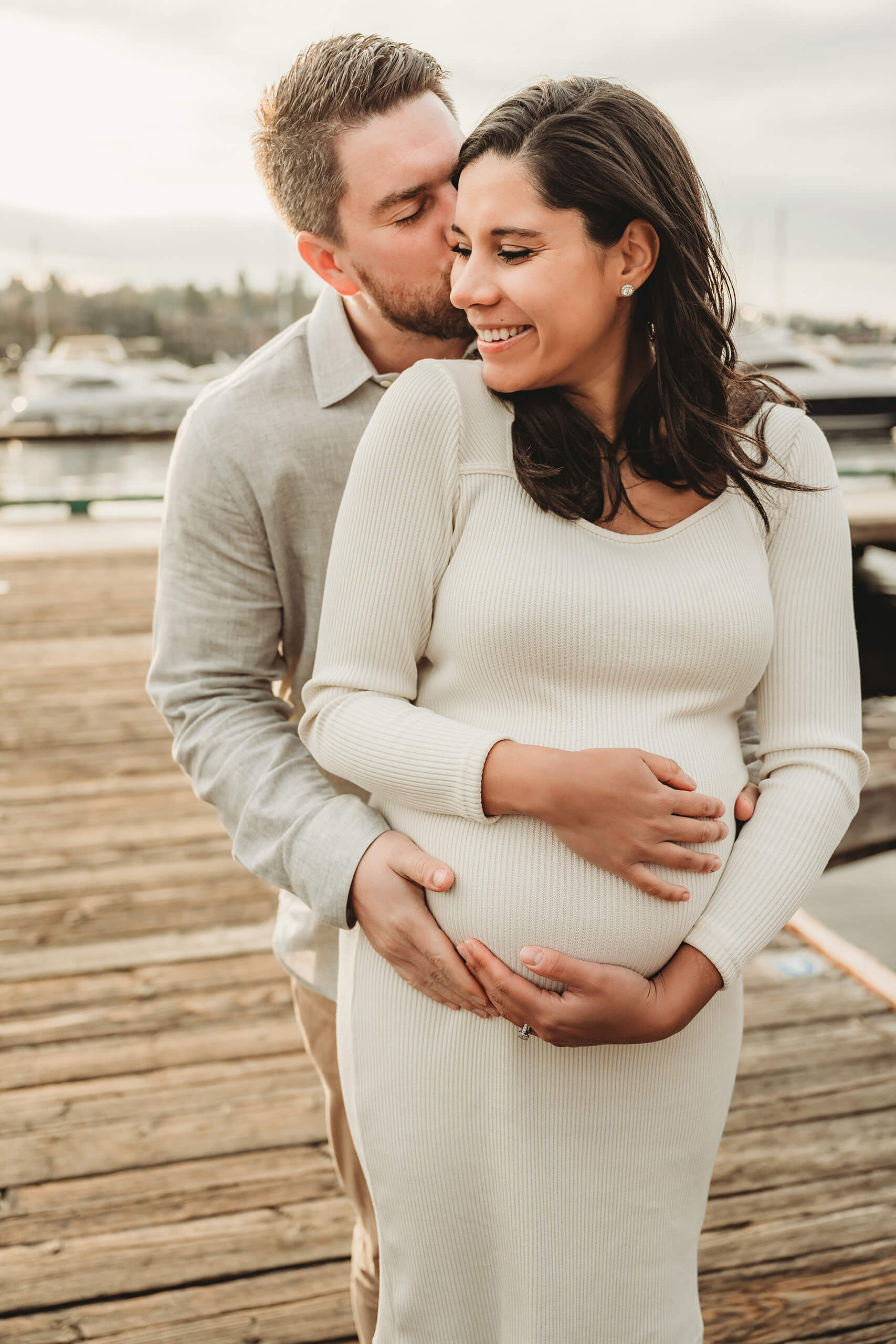 Husband kissing his wife during a winter pregnancy photo shoot in Kirkland, WA