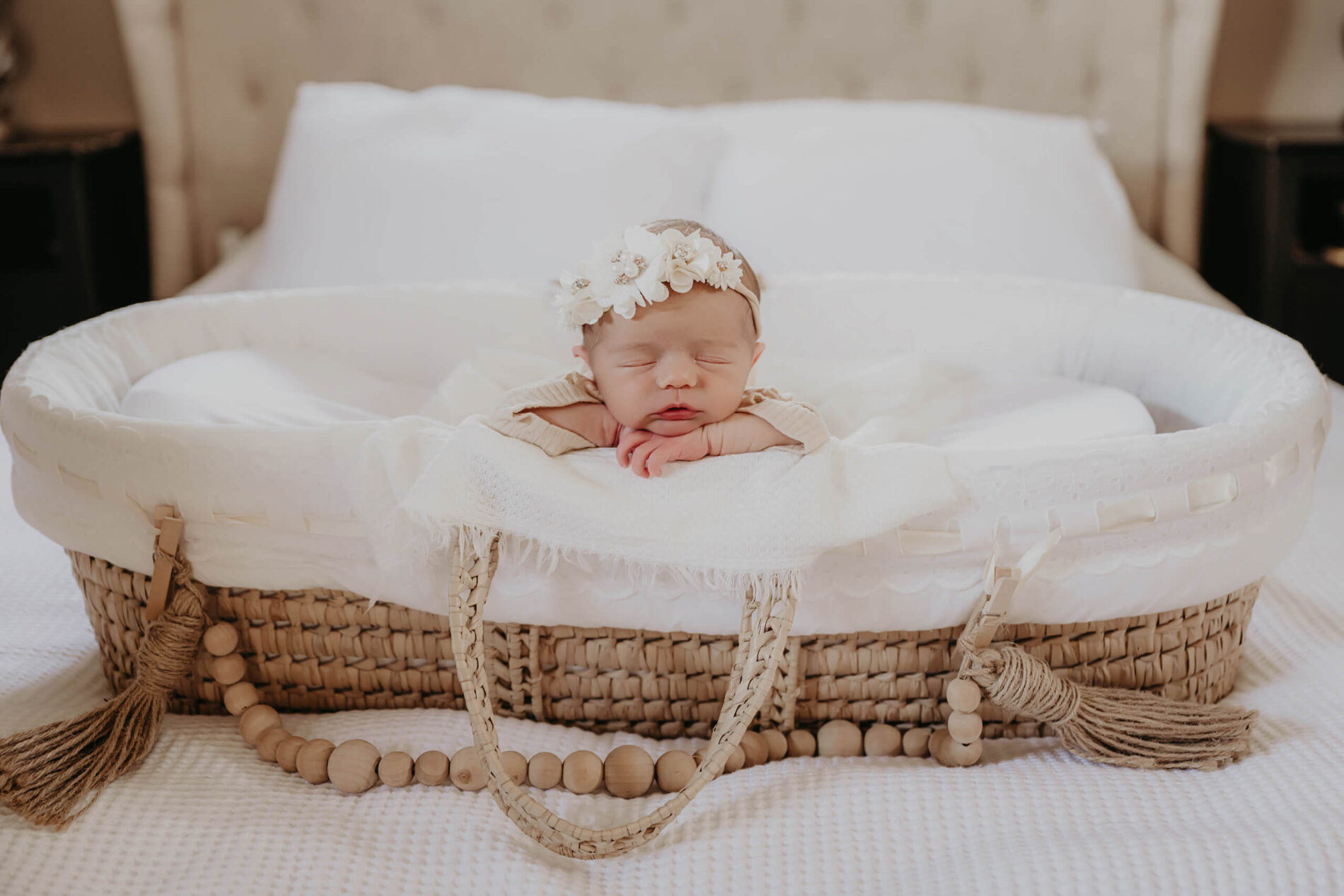 Natural light newborn photo idea of a baby girl in a basket on top of the bed