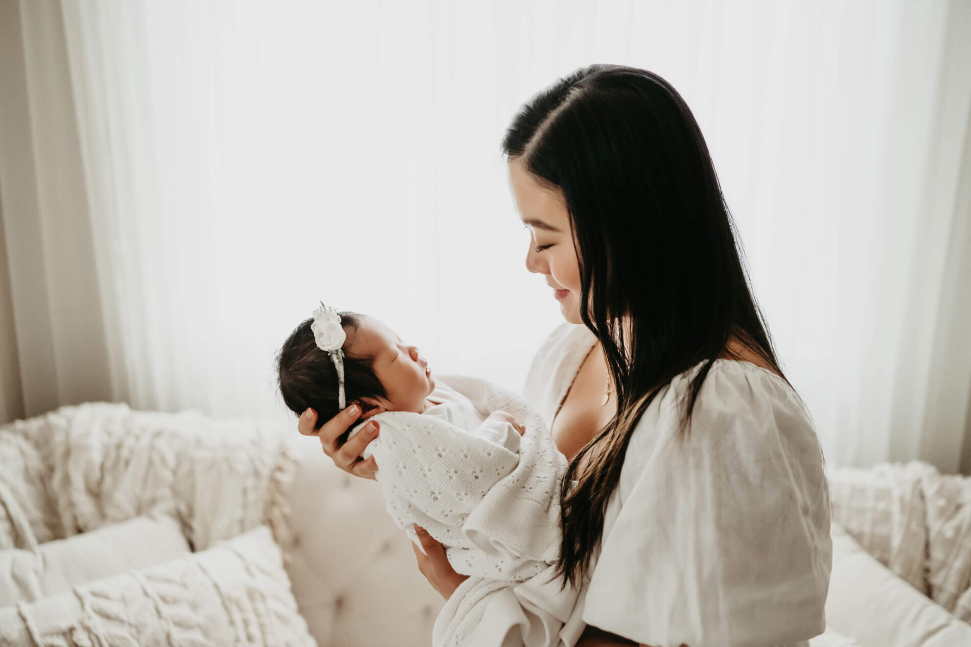 Family newborn photo of baby girl held in mom's arms in a Seattle area studio