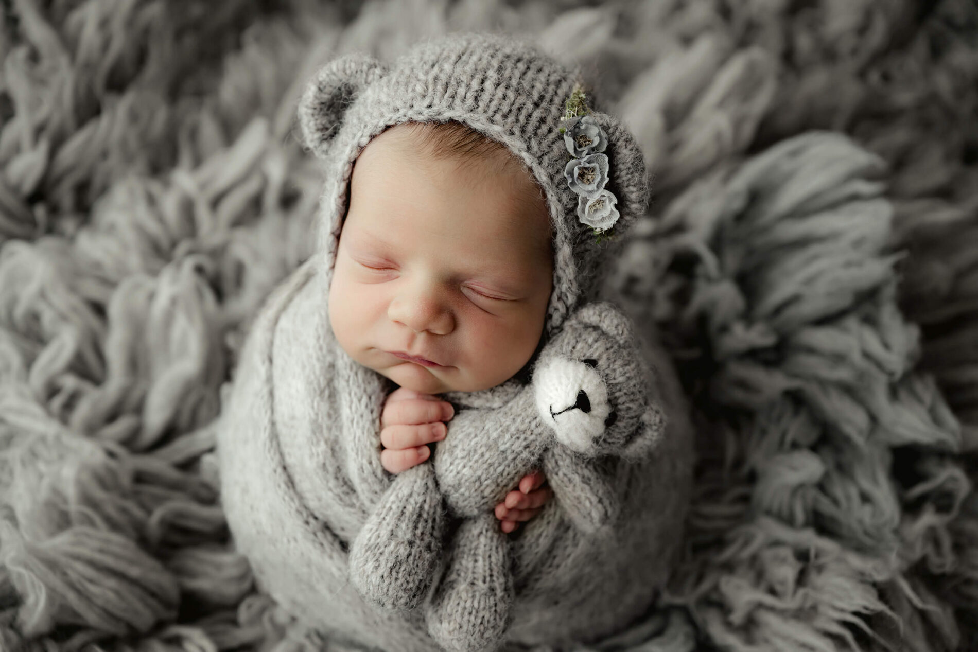 Cute photo of baby girl during newborn photo shoot with parents