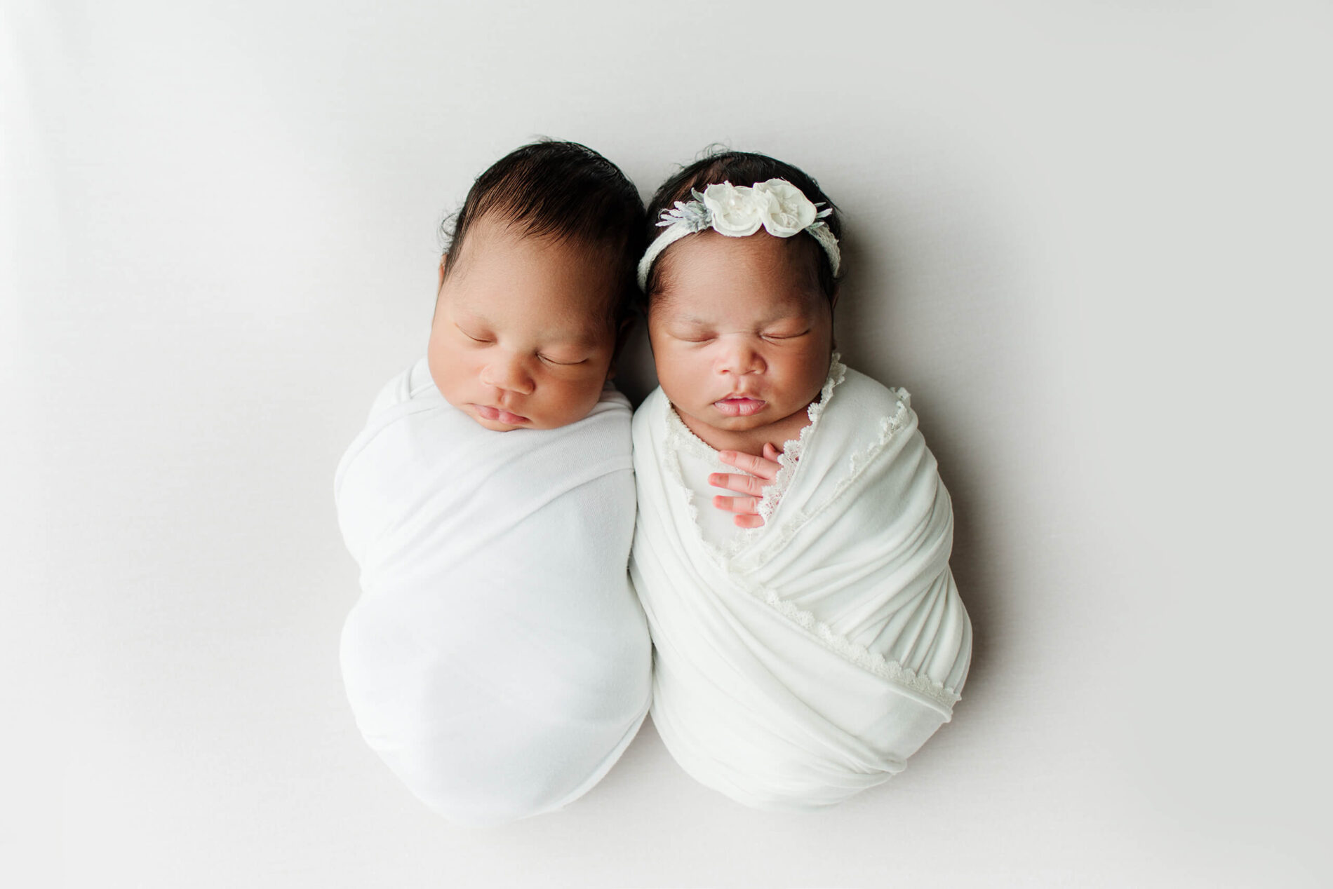 Twins posed during a newborn photo shoot in a studio
