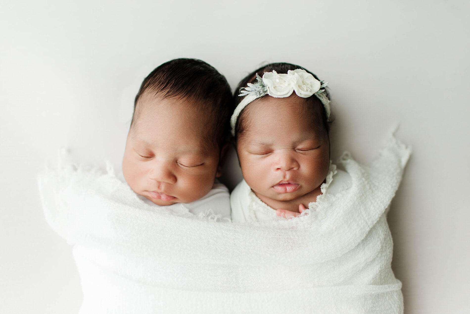 Twins posed during a newborn photo shoot in a studio