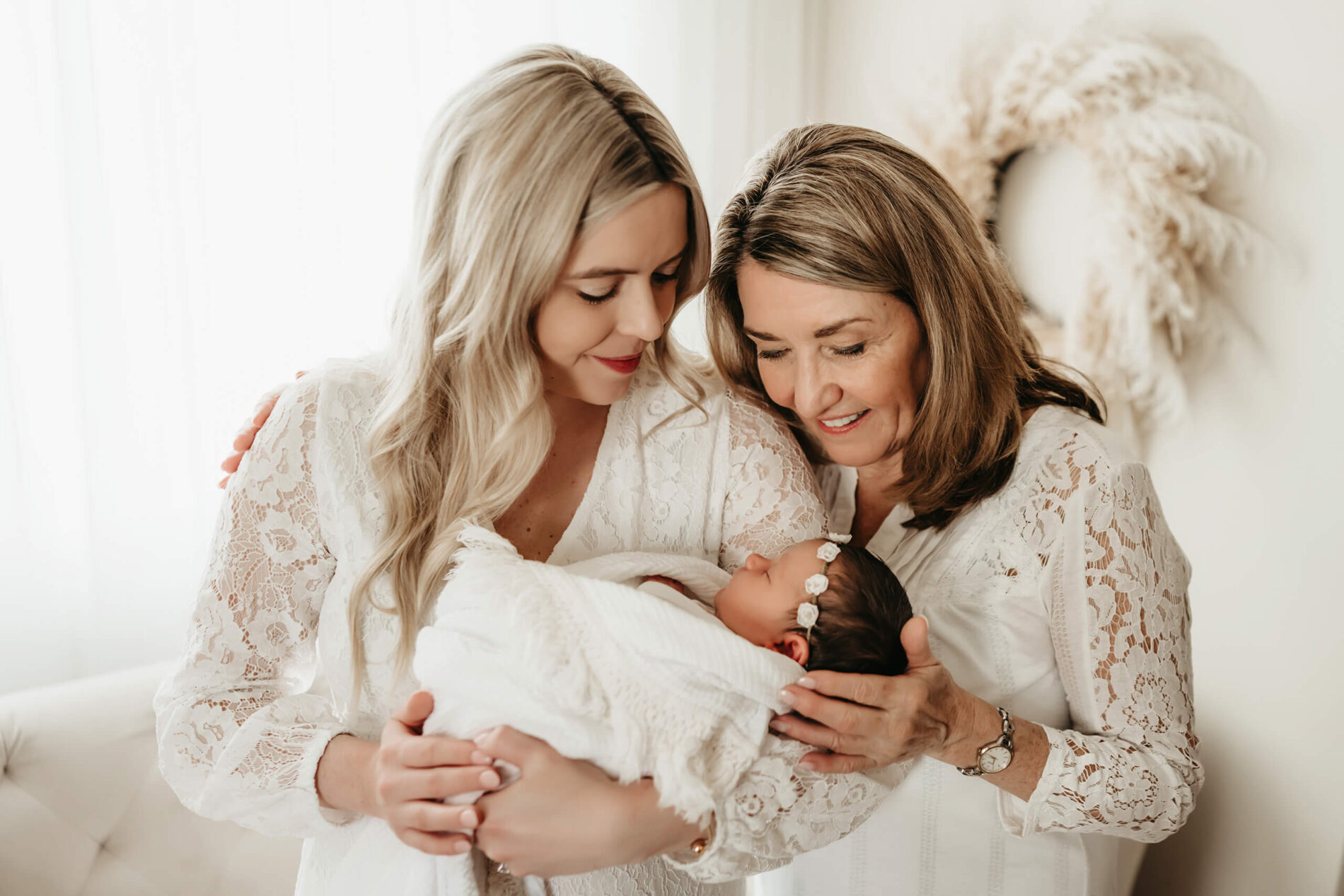 Family newborn photo shoot with baby girl, mom, and grandma