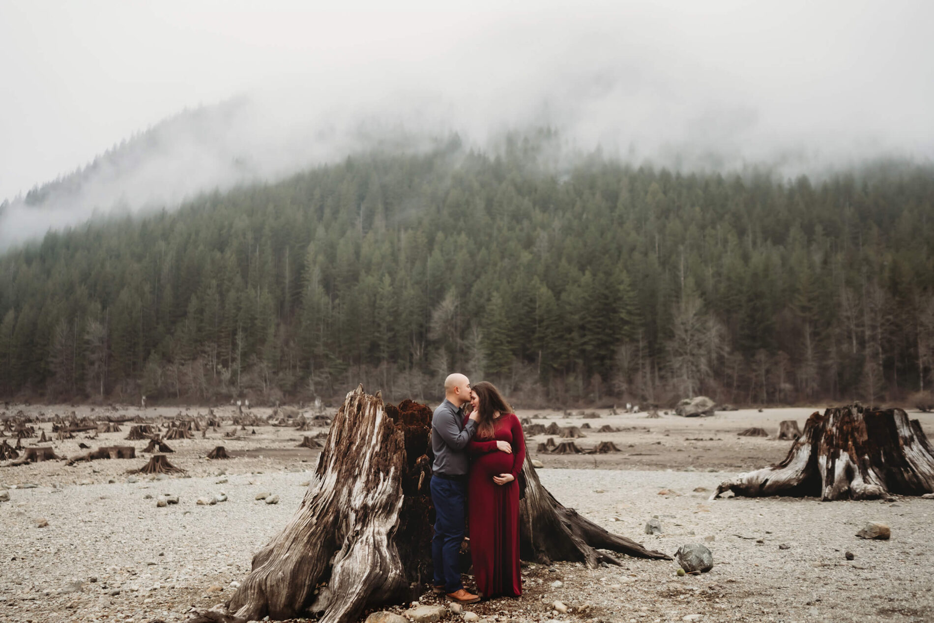 A couple kissing during an outdoor winter maternity shoot