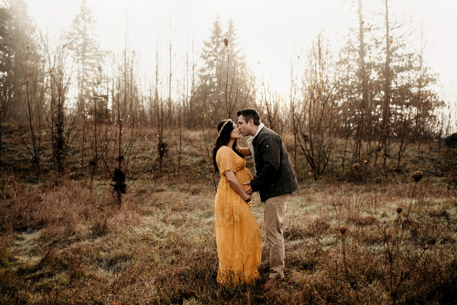 A couple kissing during a winter maternity photo shoot